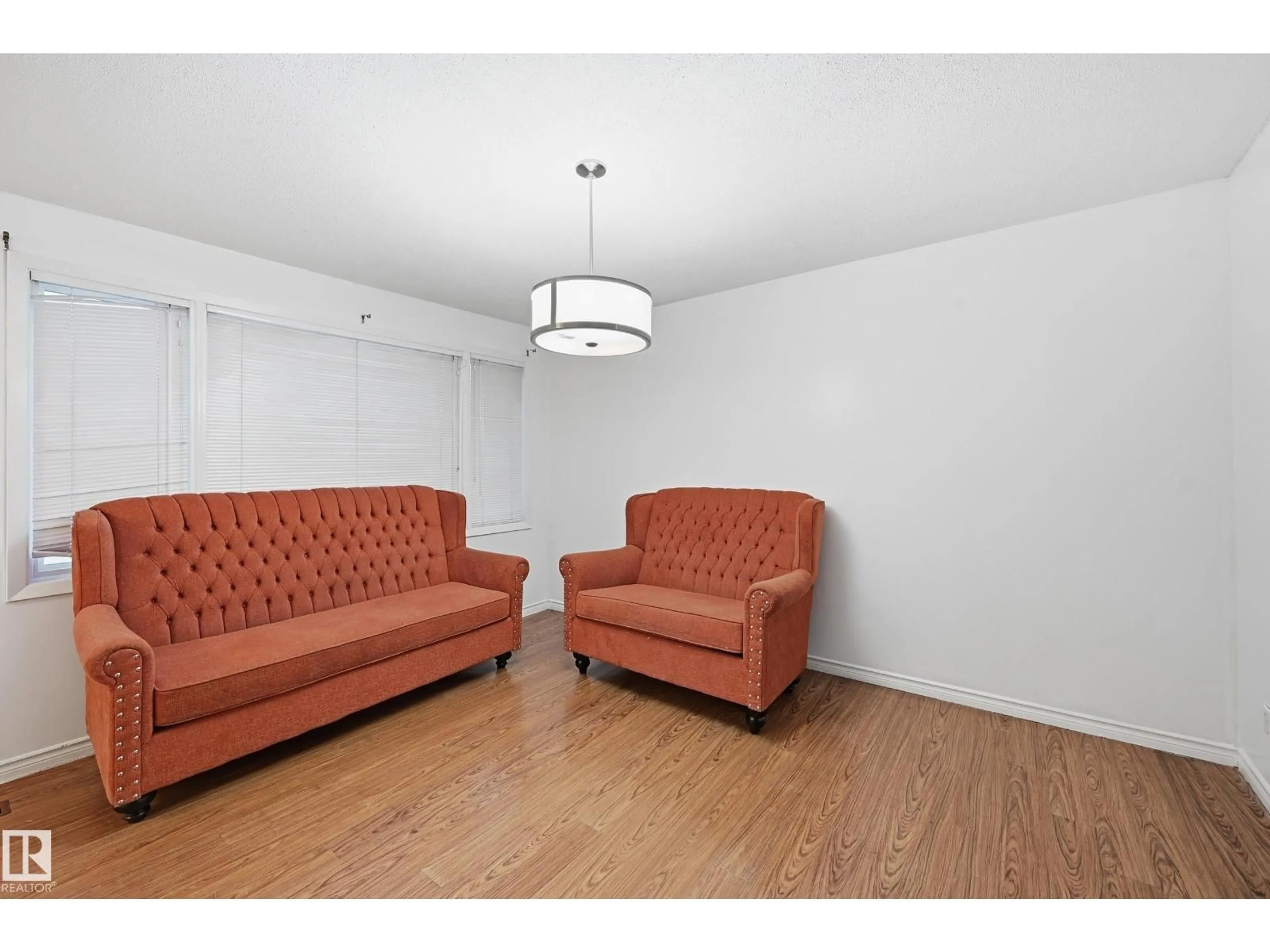 Living room with furniture, wood/laminate floor for 10810 132 AV, Edmonton Alberta T5E0Z6