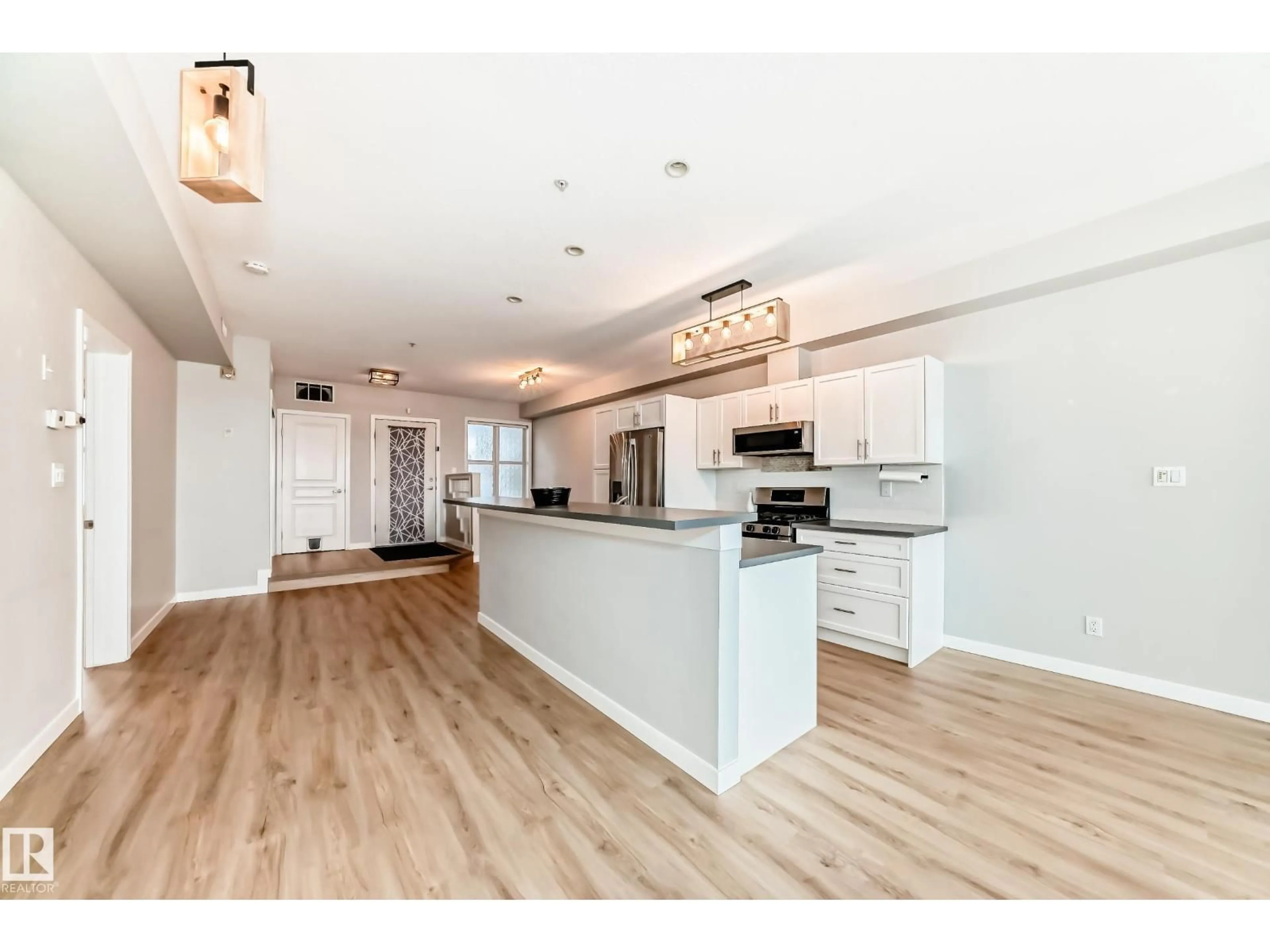 Open concept kitchen, wood/laminate floor for #115 - 9507 101 AV, Edmonton Alberta T5H4R1