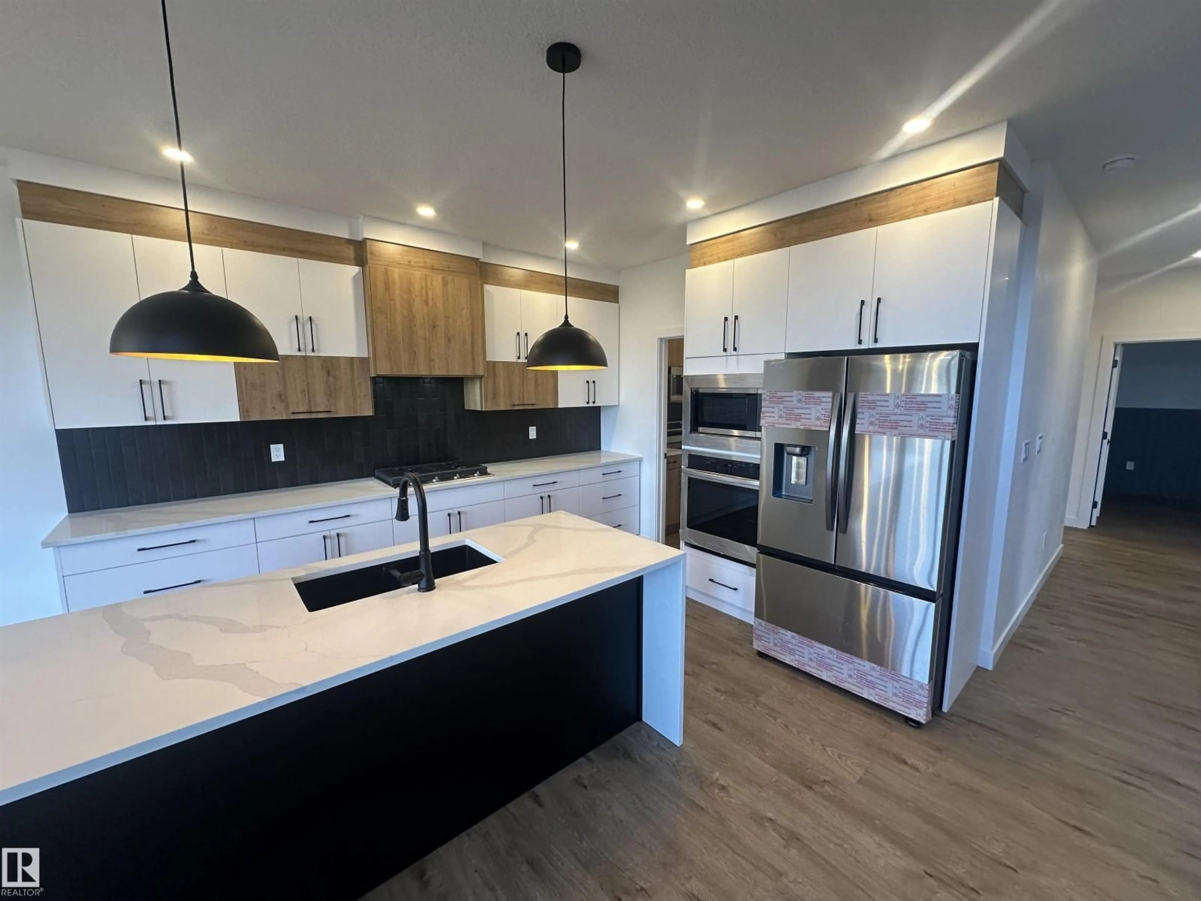 Open concept kitchen, wood/laminate floor for 205 KETTYL CO, Leduc Alberta T9E1S1