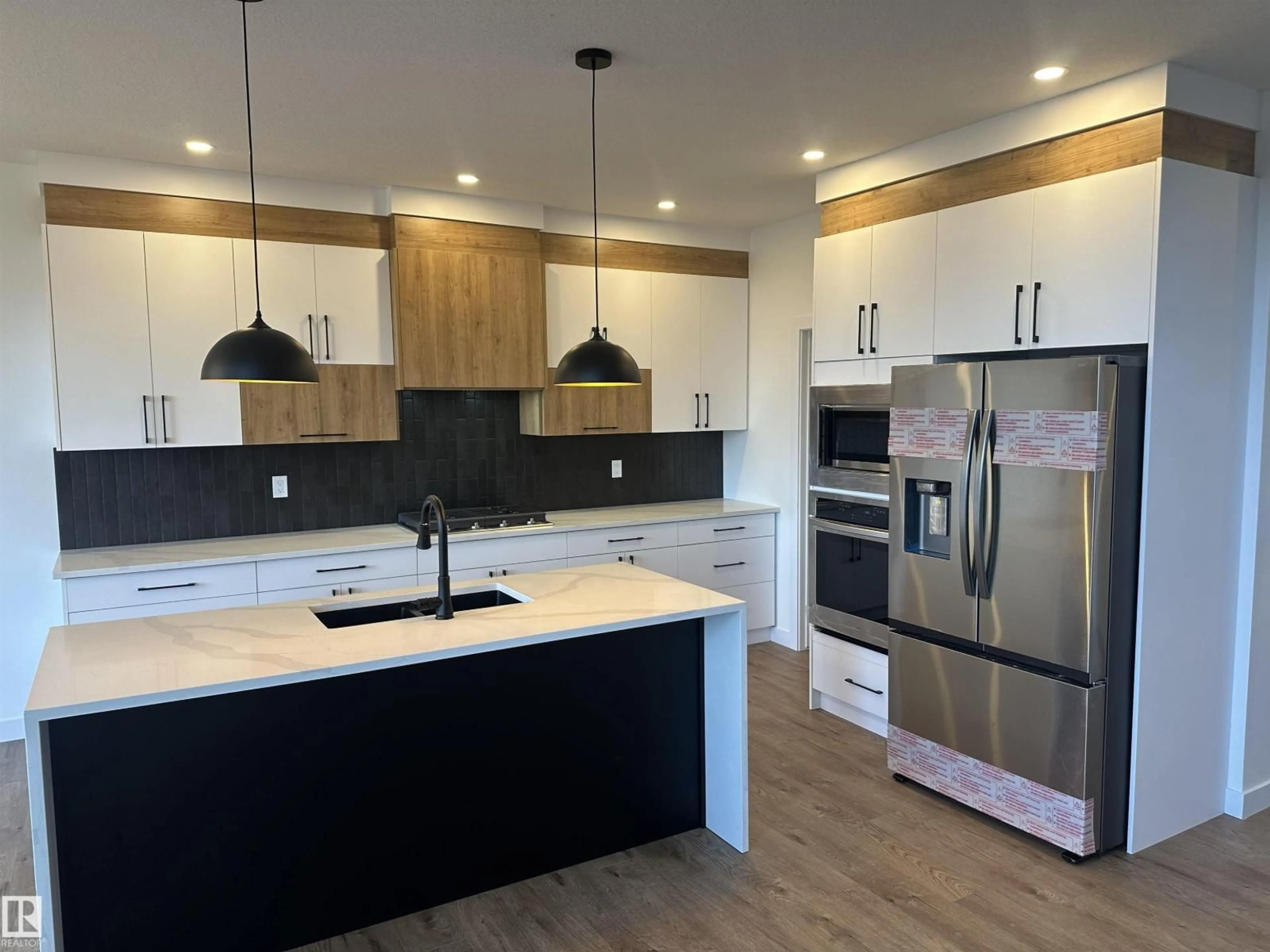 Open concept kitchen, wood/laminate floor for 205 KETTYL CO, Leduc Alberta T9E1S1