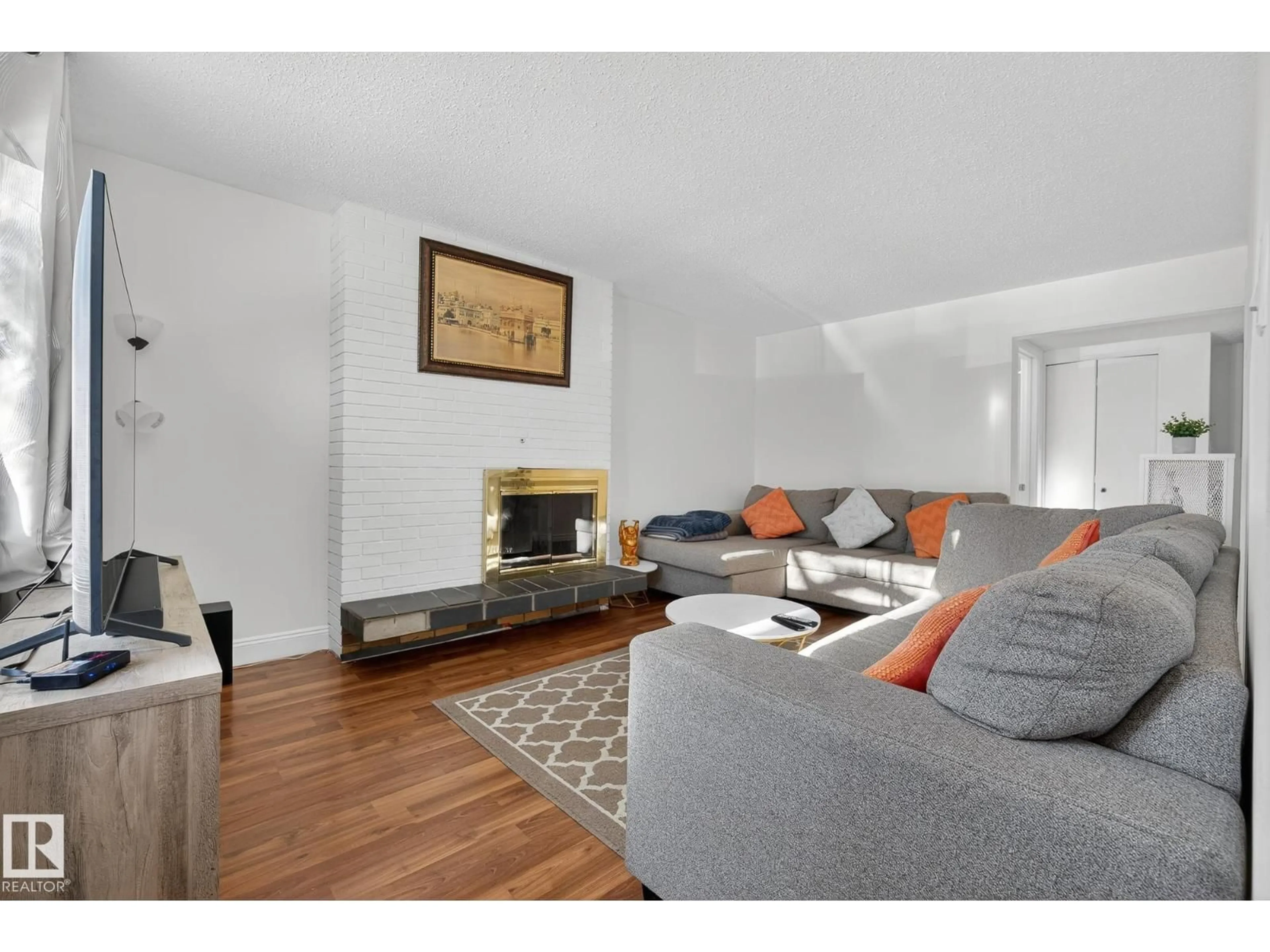 Living room with furniture, wood/laminate floor for 10602 66 AV, Edmonton Alberta T6H1X6