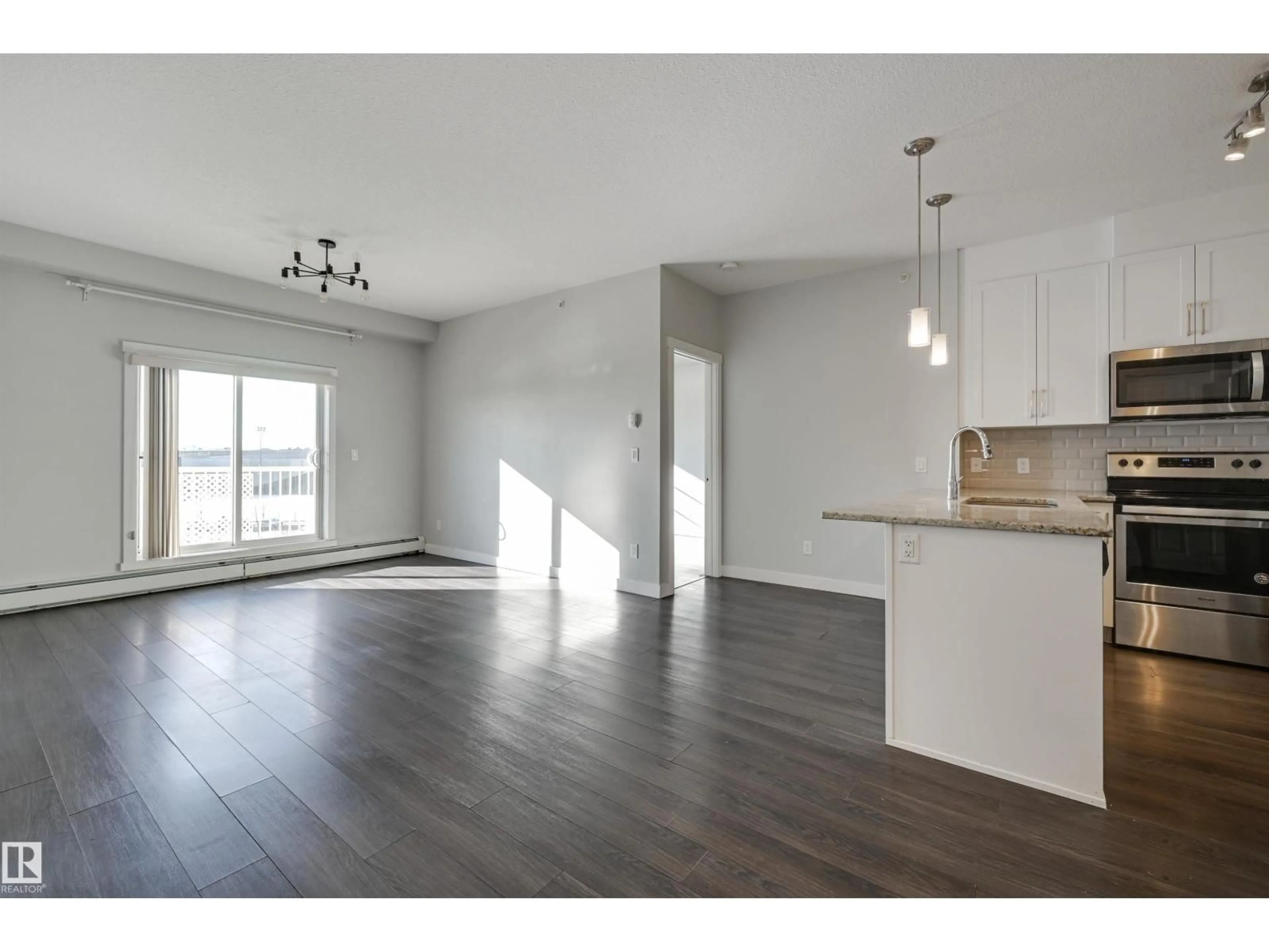 Open concept kitchen, wood/laminate floor for 411 - 3670 139 AV, Edmonton Alberta T5Y3N5