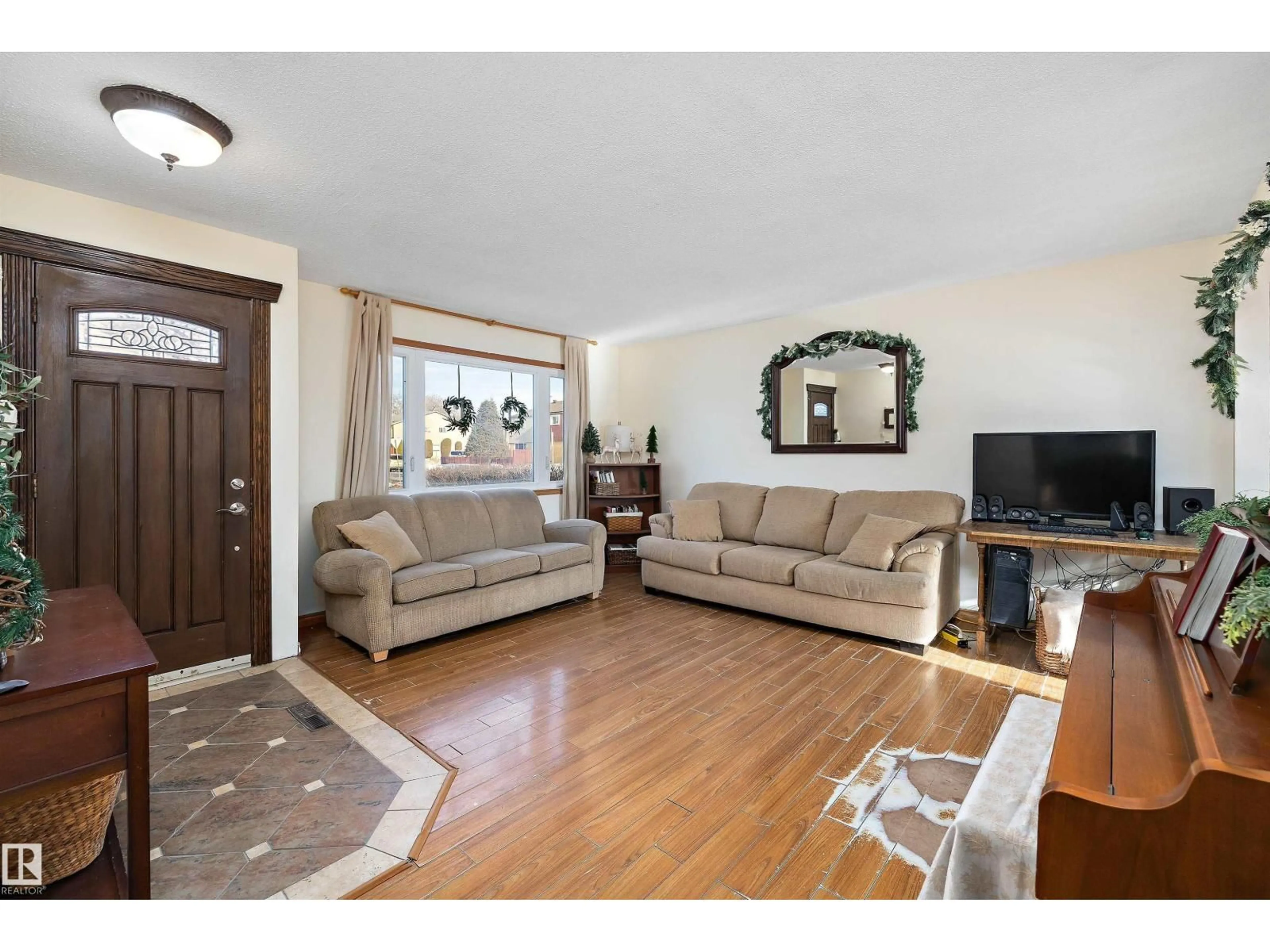 Living room with furniture, wood/laminate floor for 5703 143 AV, Edmonton Alberta T5A1J9