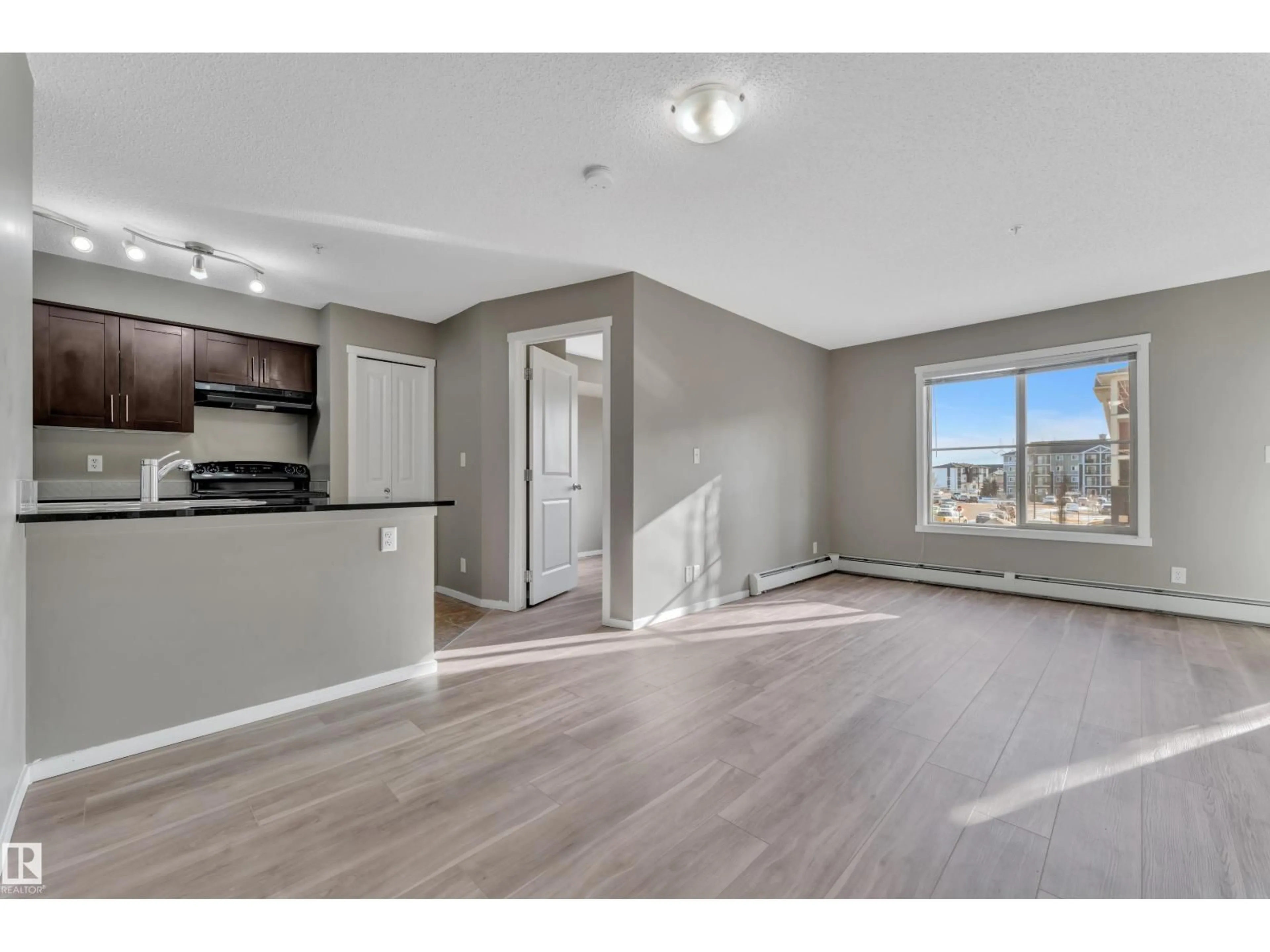 Open concept kitchen, wood/laminate floor for 216 - 5804 MULLEN PL, Edmonton Alberta T6R0W3