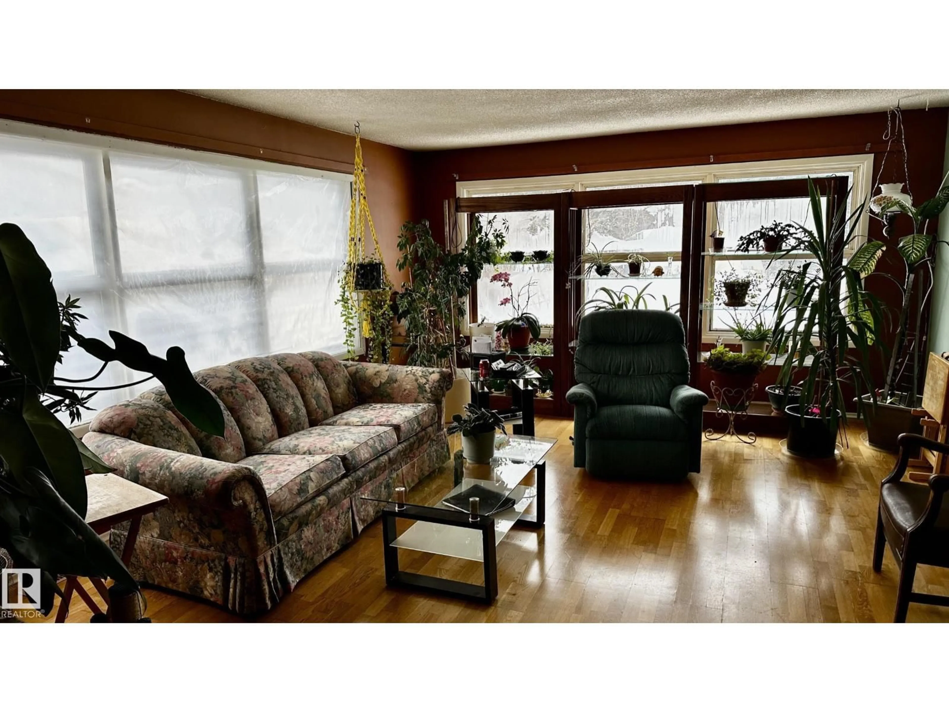 Living room with furniture, wood/laminate floor for 52012 HWY 21, Rural Strathcona County Alberta T8B1J6
