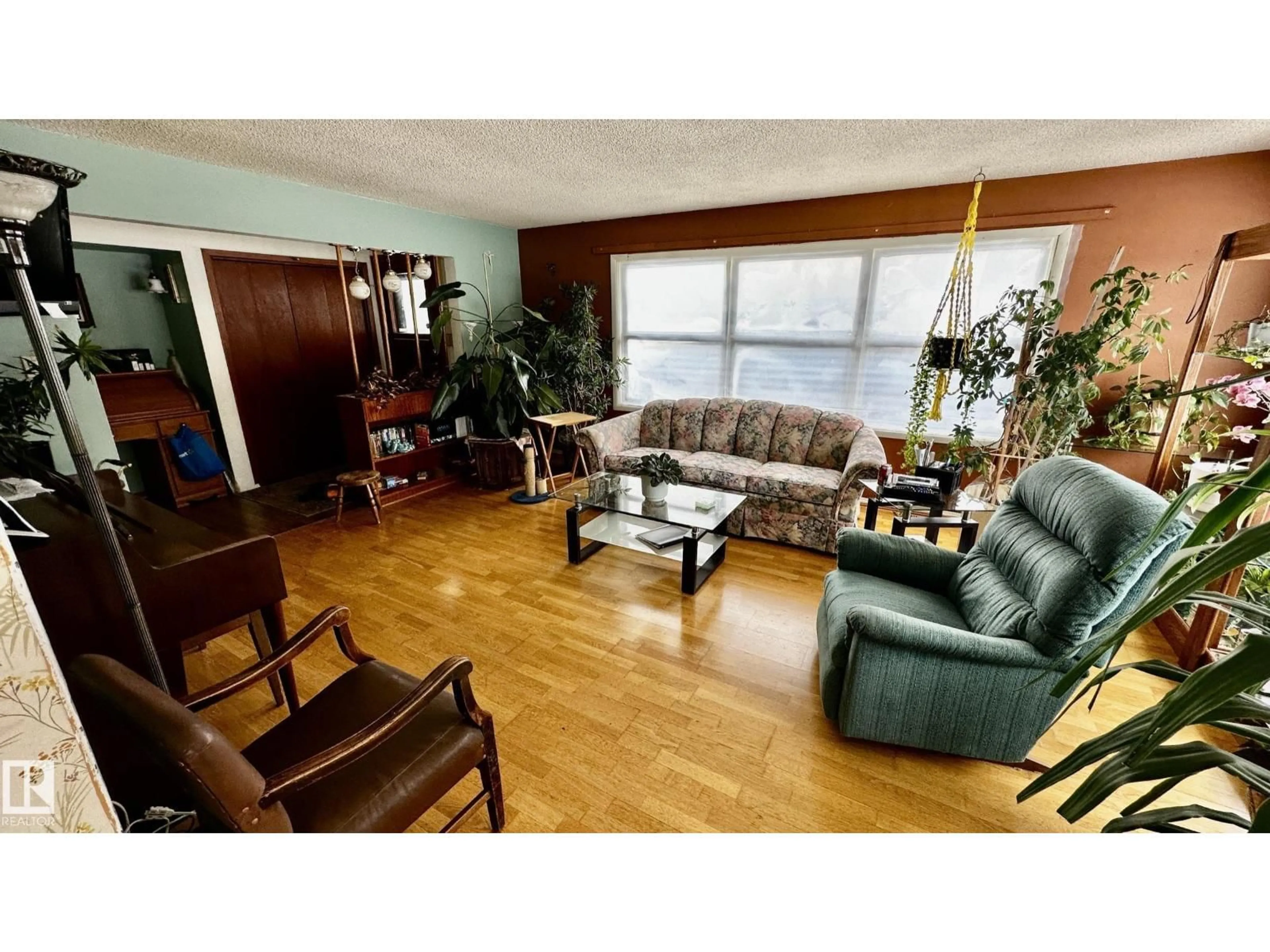 Living room with furniture, wood/laminate floor for 52012 HWY 21, Rural Strathcona County Alberta T8B1J6