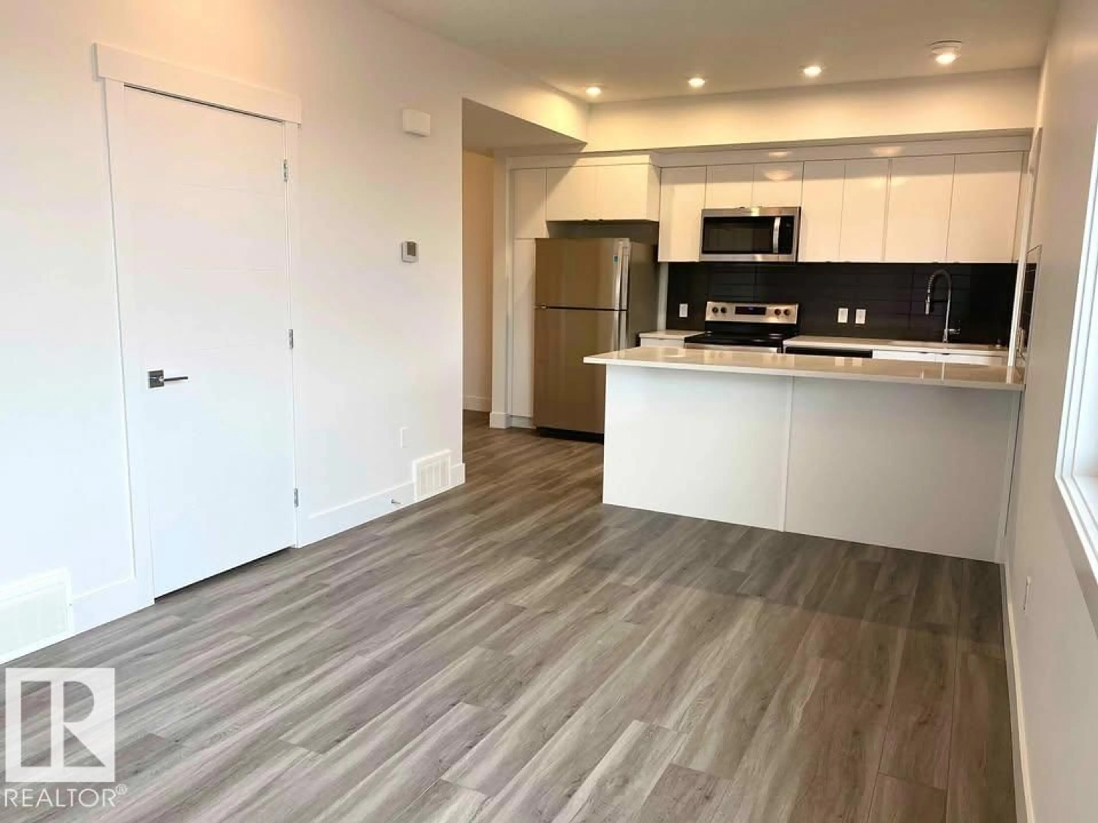 Open concept kitchen, wood/laminate floor for 10 446 ALLARD BV SW, Edmonton Alberta T6W3S7