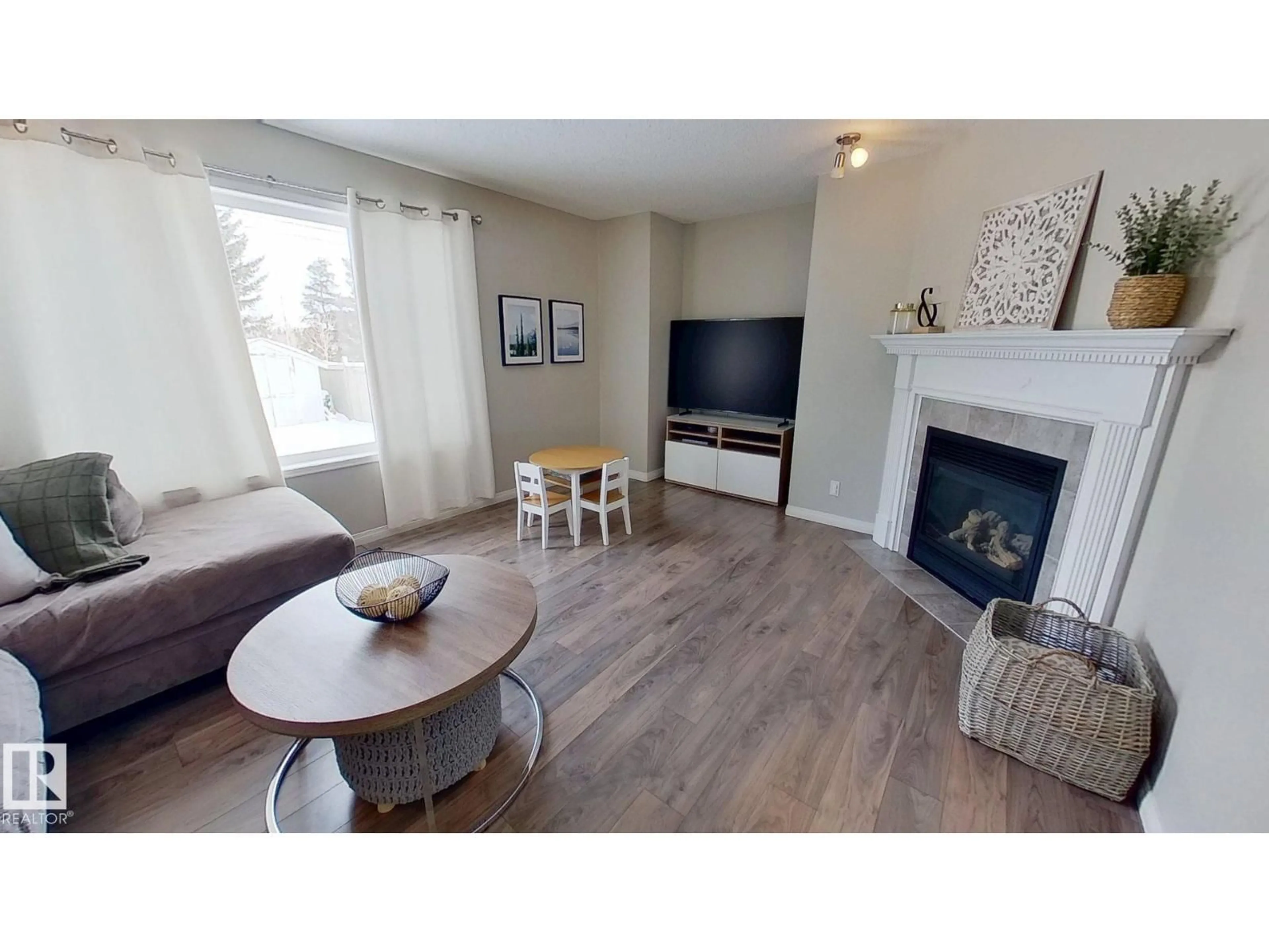 Living room with furniture, wood/laminate floor for 24 PIPESTONE DR, Devon Alberta T9G1S1