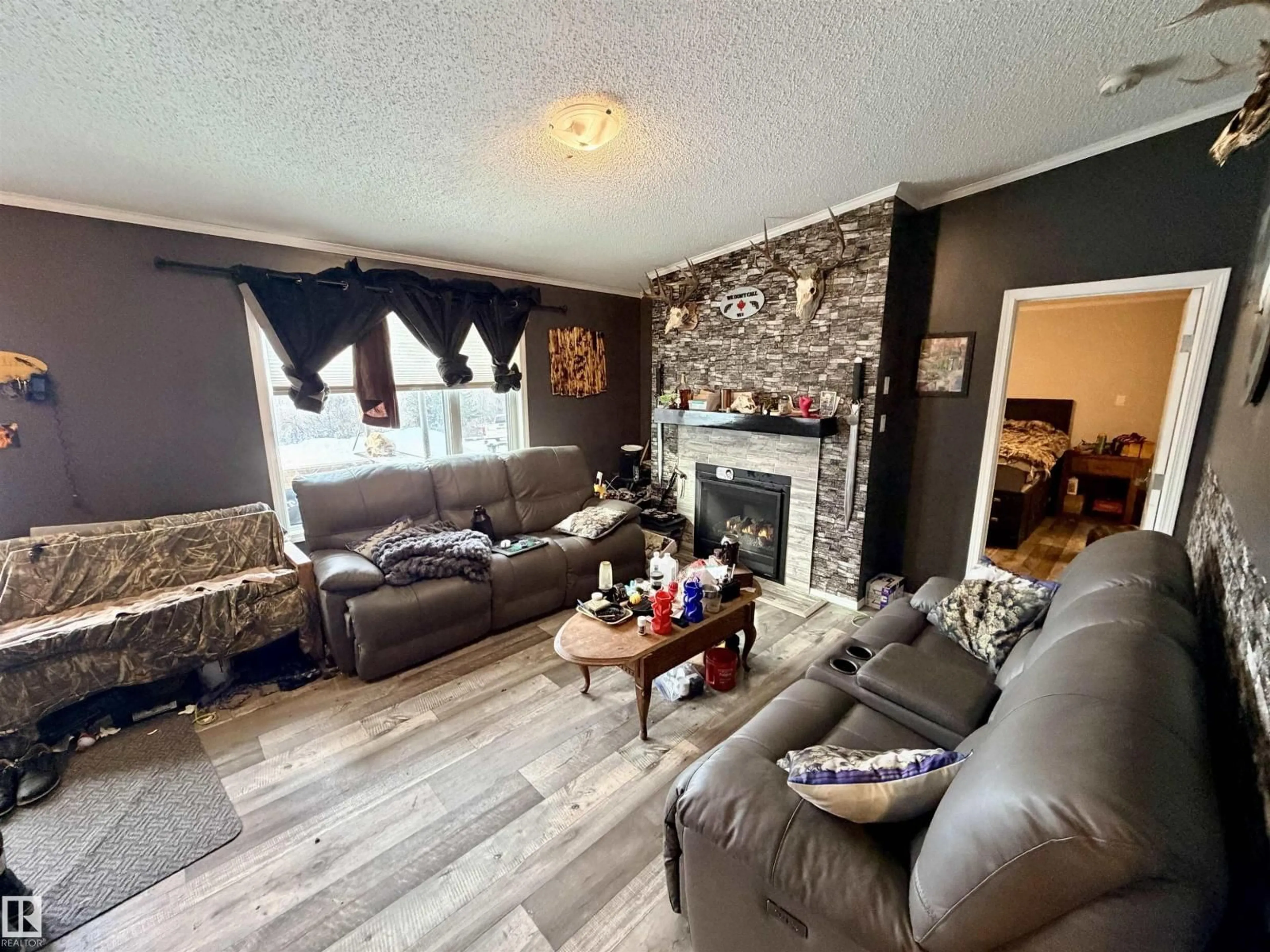 Living room with furniture, wood/laminate floor for 54002 RR 105, Rural Two Hills County Alberta T0B4K0