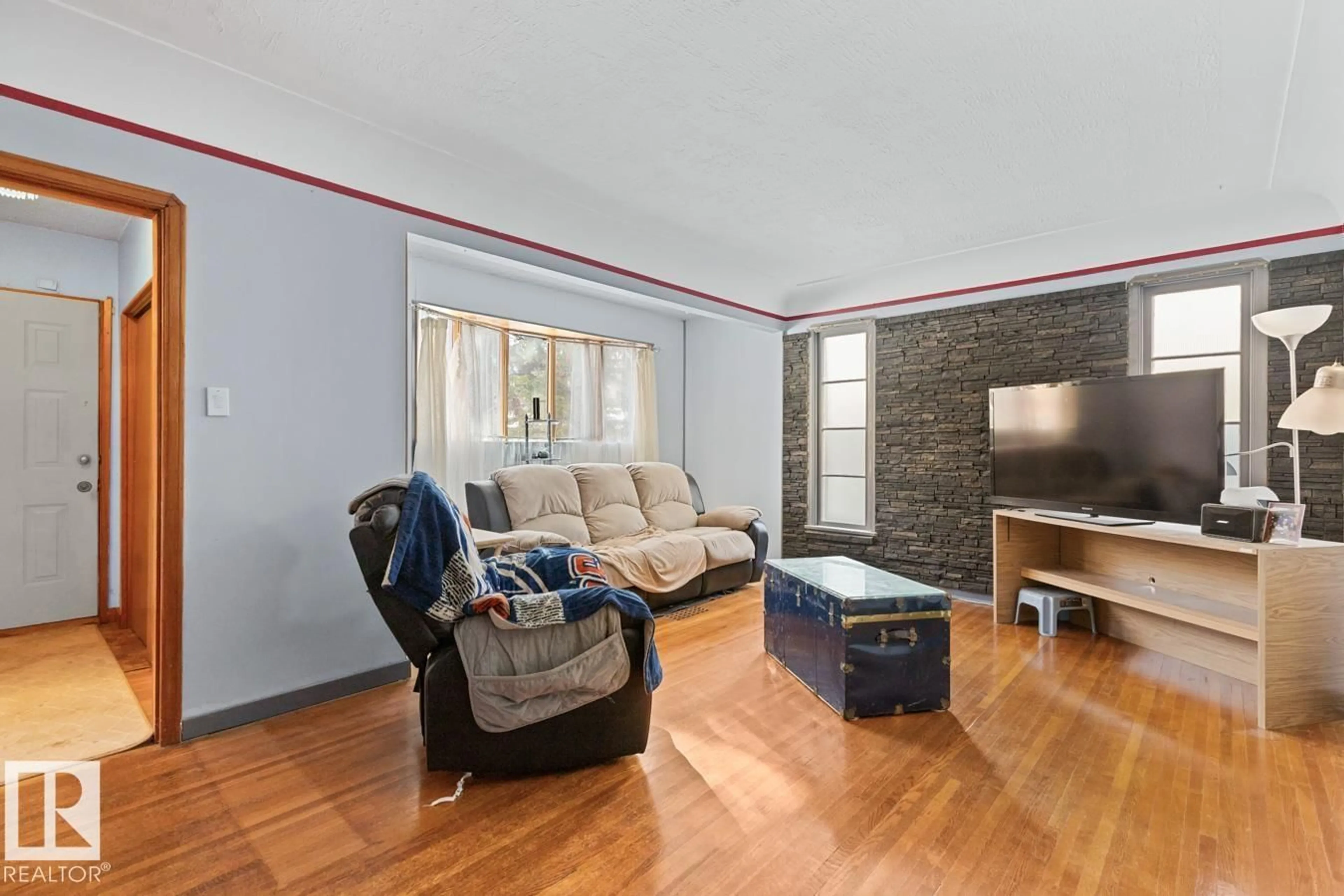 Living room with furniture, wood/laminate floor for 8906 94 AV, Edmonton Alberta T6C1W7