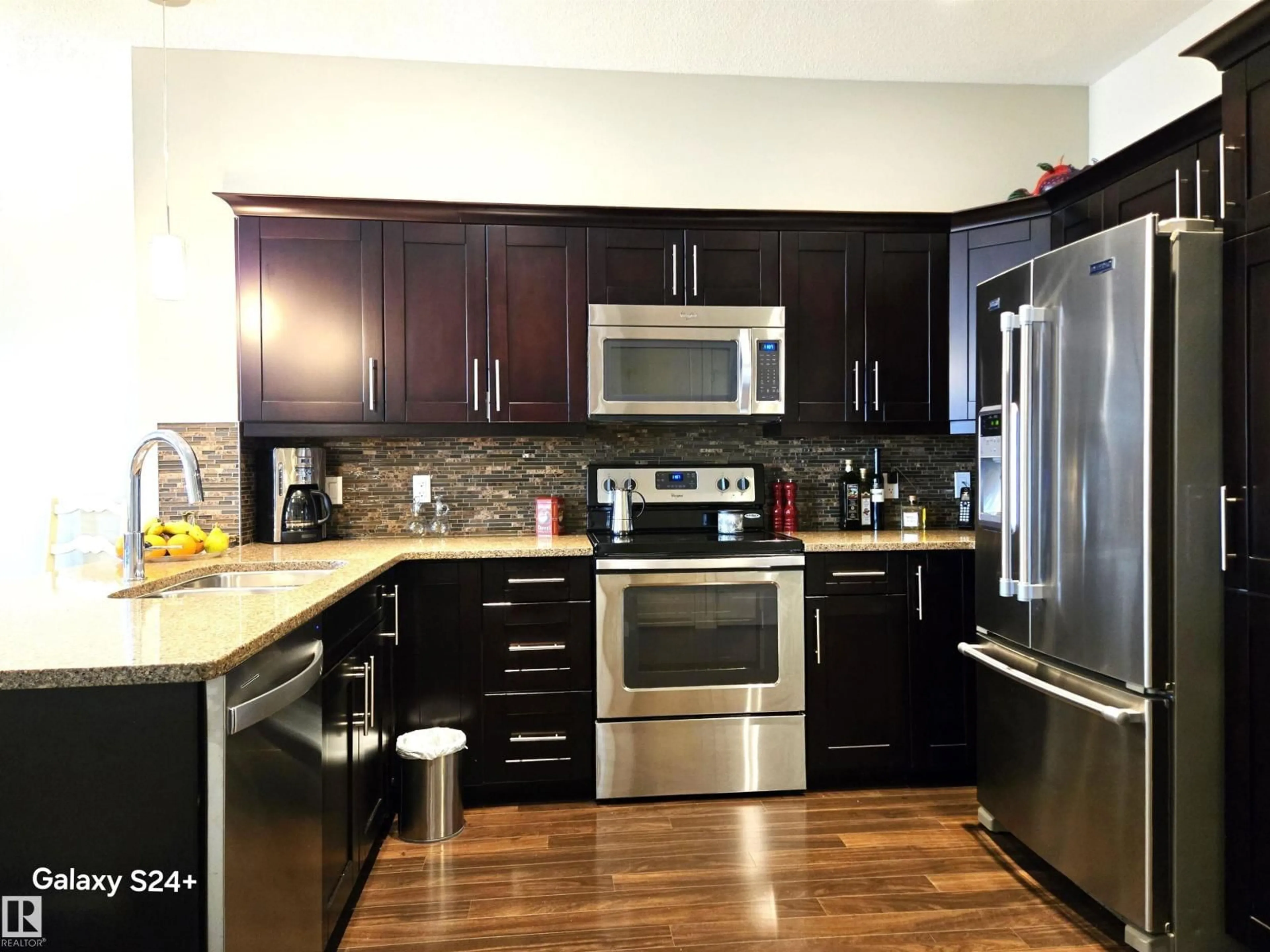 Open concept kitchen, wood/laminate floor for #407 - 1031 173 ST, Edmonton Alberta T6W3E4