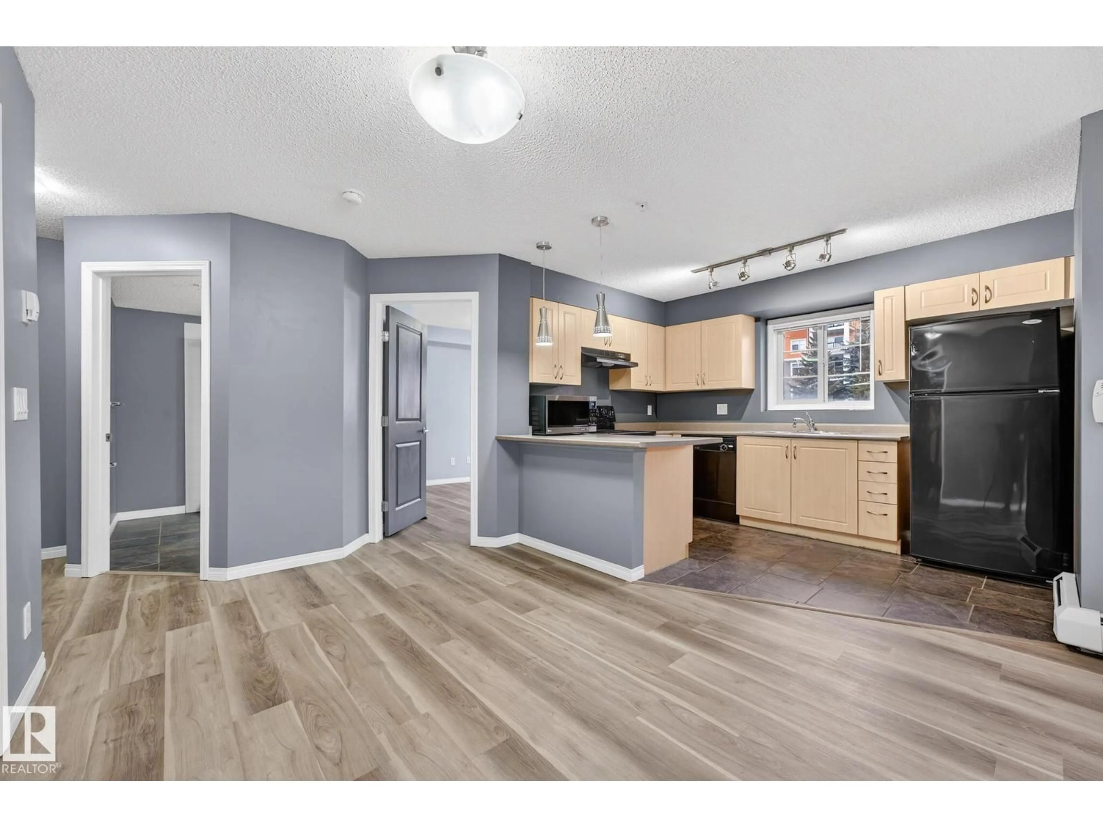 Open concept kitchen, wood/laminate floor for #102 - 11445 ELLERSLIE RD, Edmonton Alberta T5W1T1