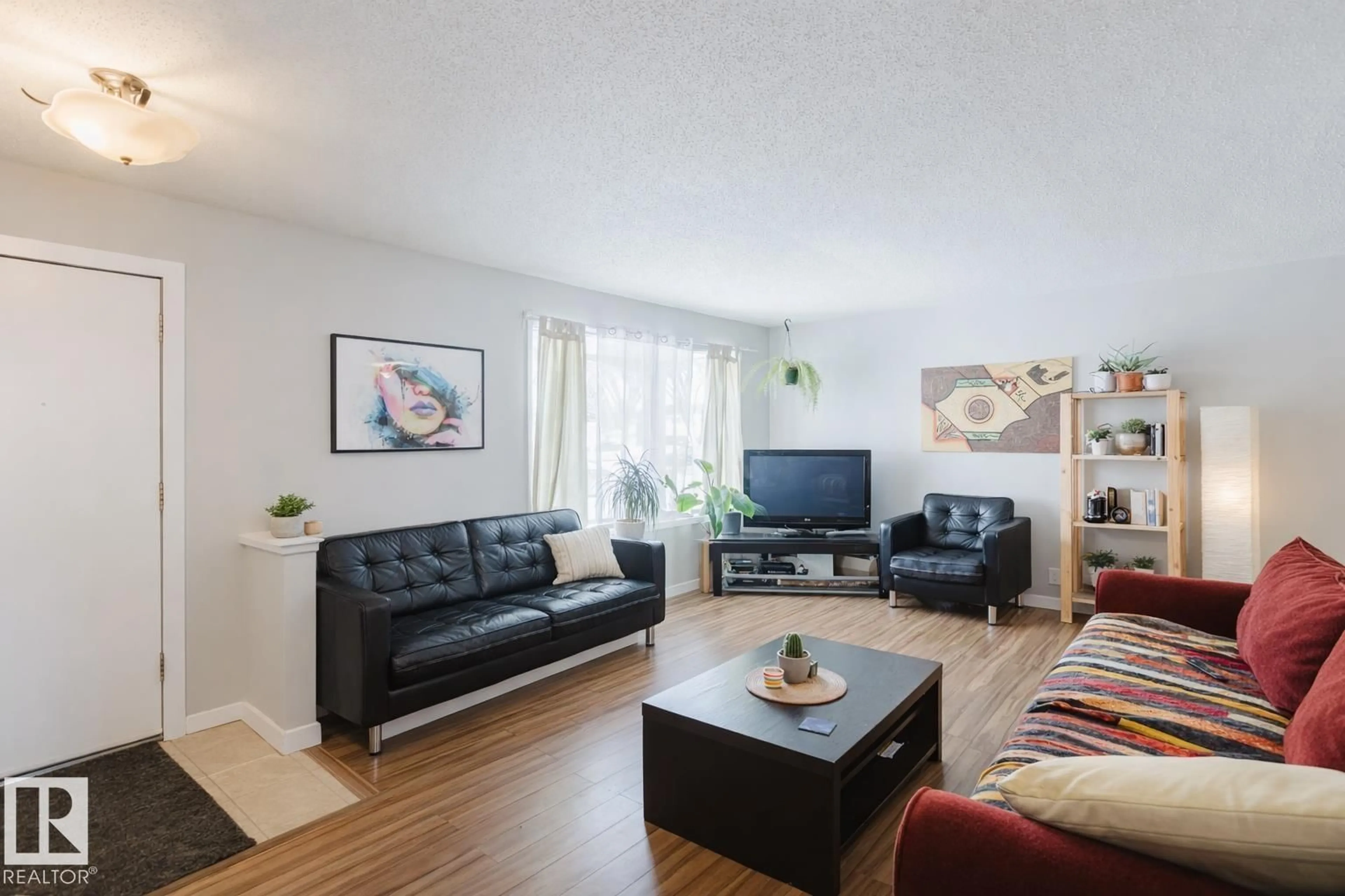 Living room with furniture, wood/laminate floor for NW - 11611 145 AV, Edmonton Alberta T5X1M1