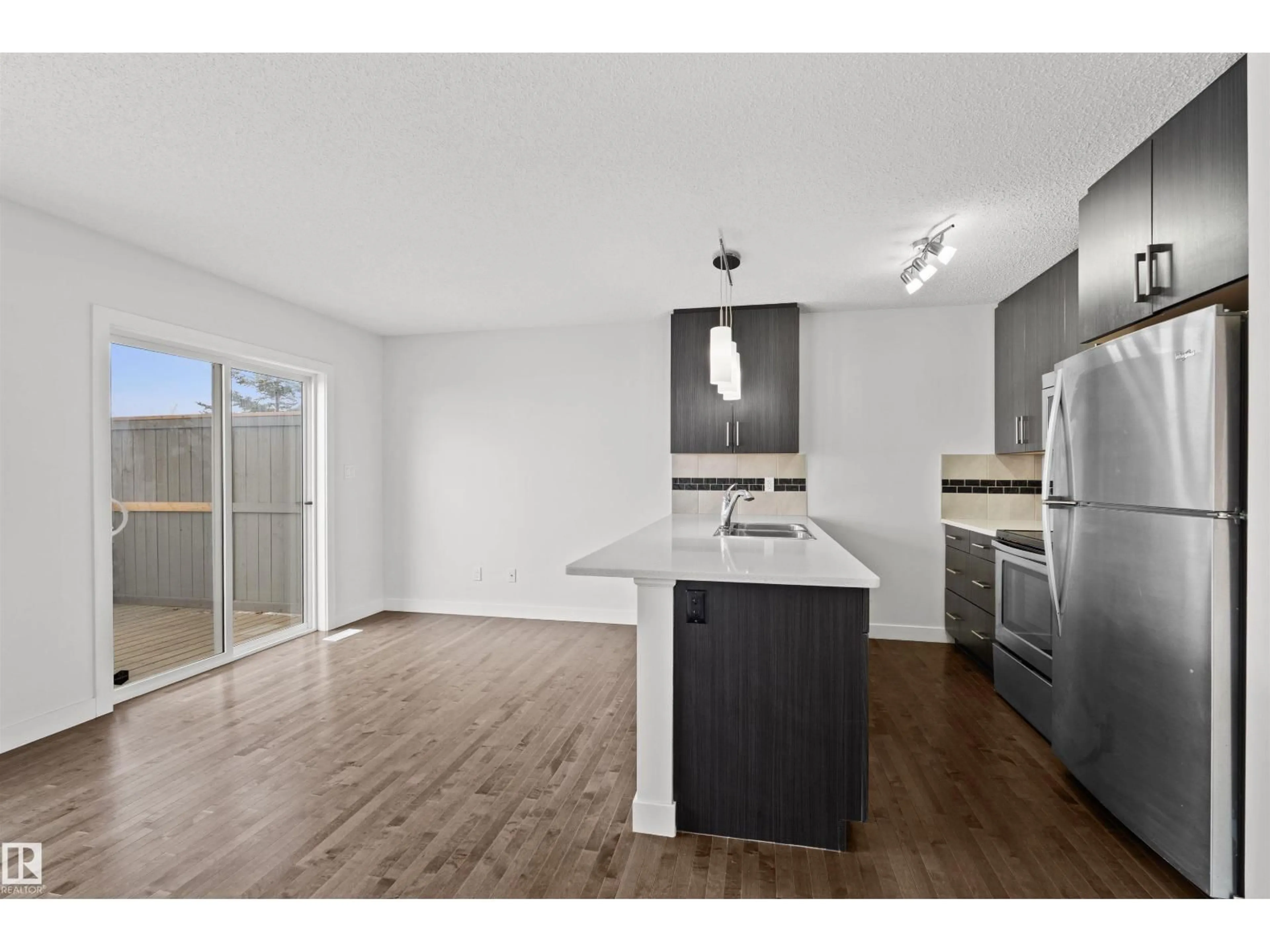 Open concept kitchen, wood/laminate floor for #23 - 2004 TRUMPETER WY, Edmonton Alberta T5S0J9