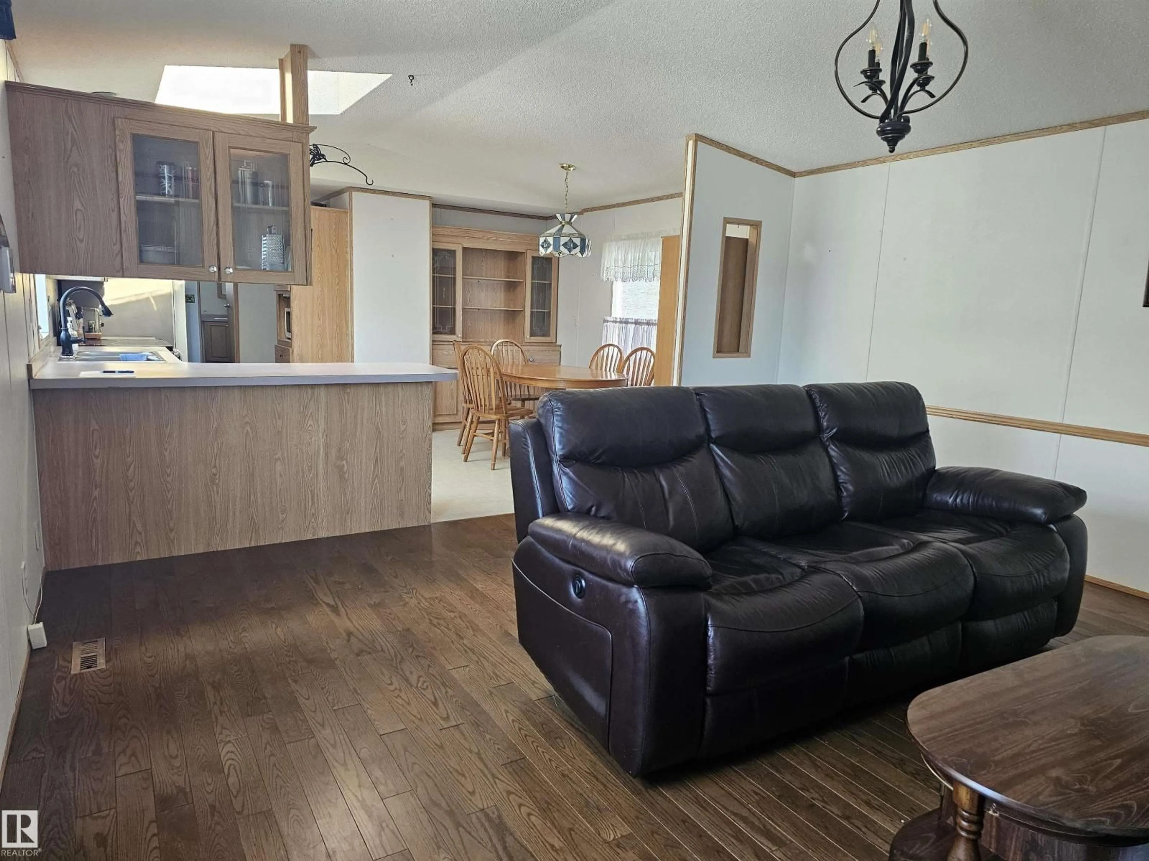Living room with furniture, wood/laminate floor for 94 - 4819 51 AVE, Millet Alberta T0C1Z0