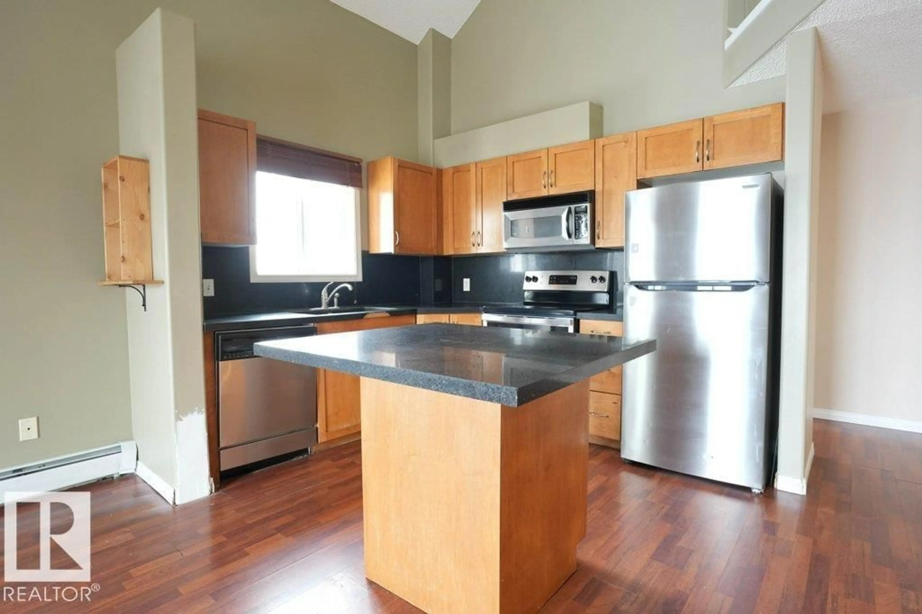 Open concept kitchen, wood/laminate floor for #406 - 3425 19 ST, Edmonton Alberta T6T1Y9