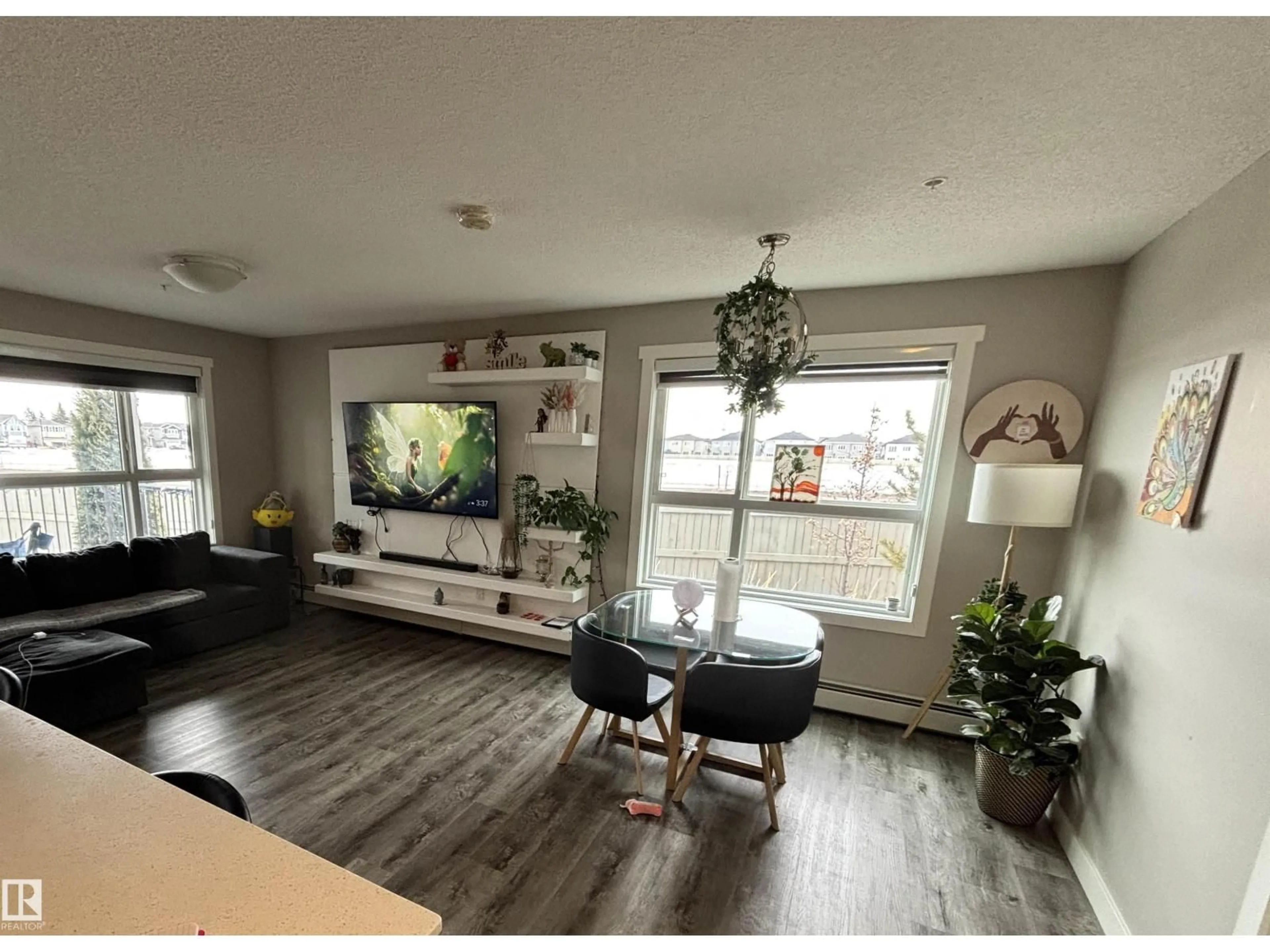 Living room with furniture, wood/laminate floor for 103 - 1503 TAMARACK BV, Edmonton Alberta T6T2J5