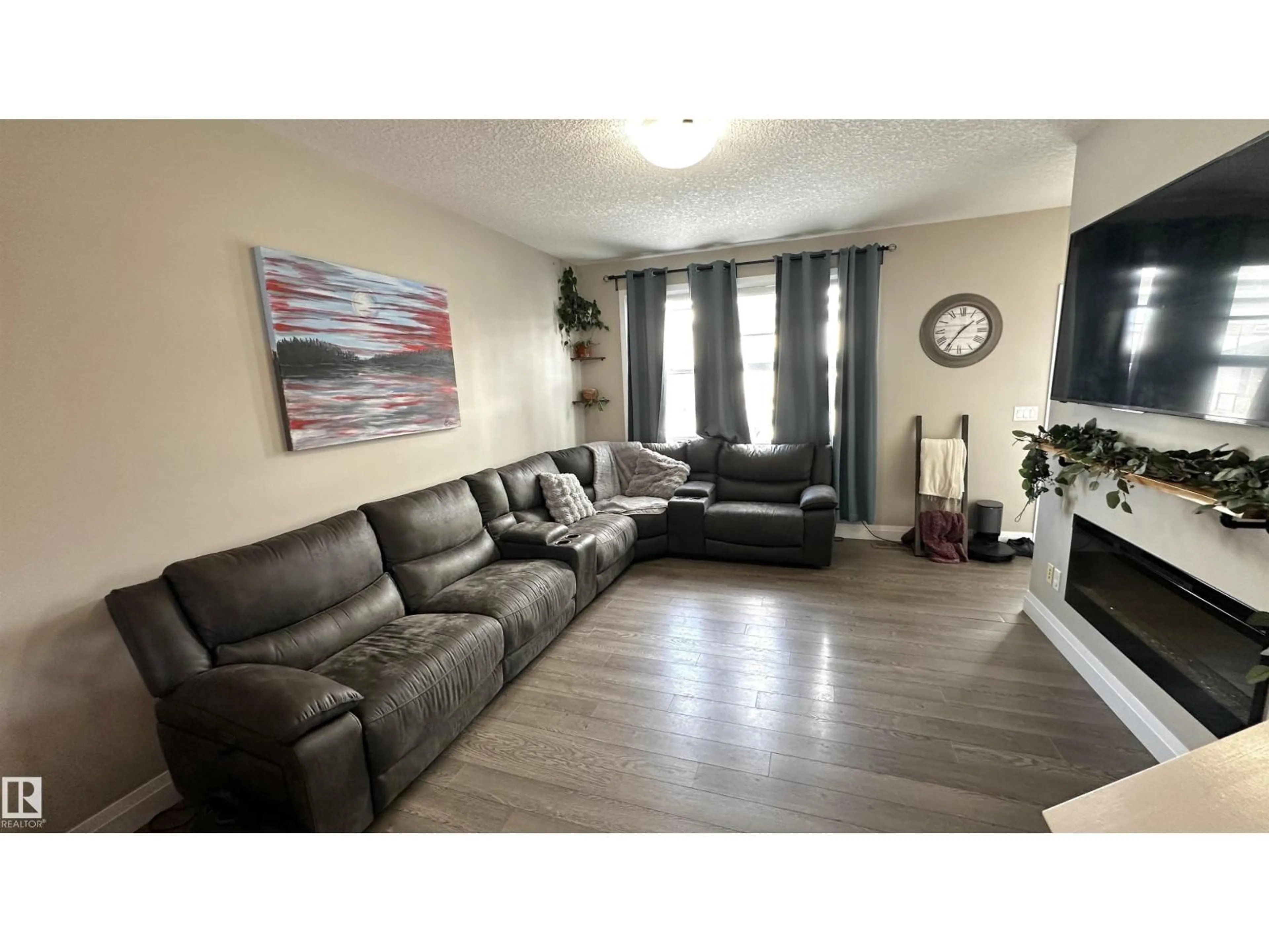 Living room with furniture, wood/laminate floor for 9813 106, Morinville Alberta T8R2P1