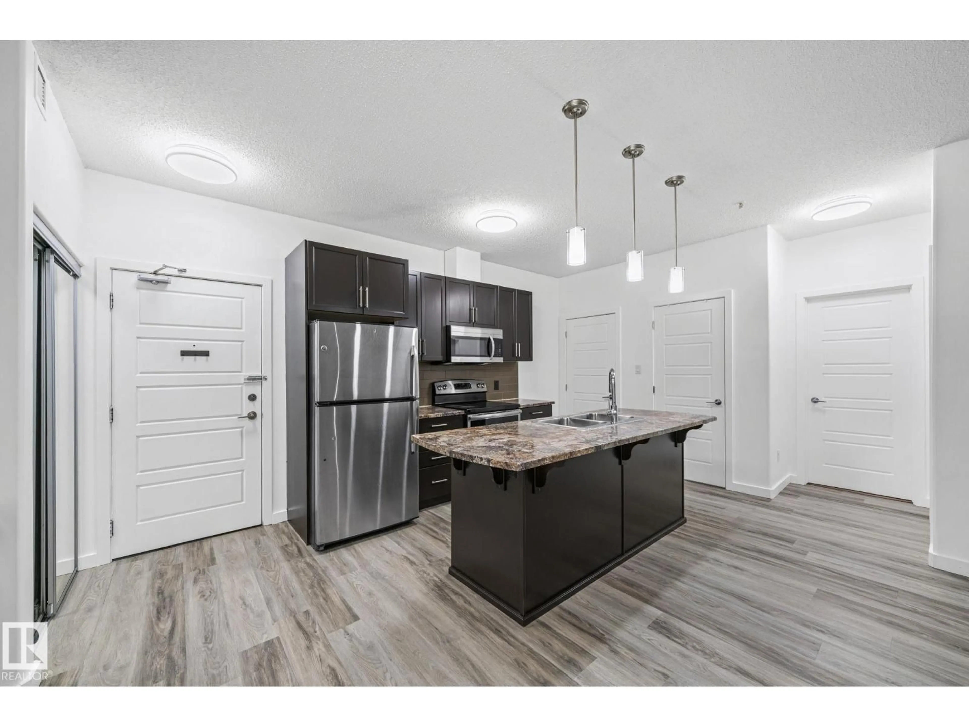 Open concept kitchen, wood/laminate floor for 320 - 119 AMBLESIDE LINK LI, Edmonton Alberta T6W2Z9