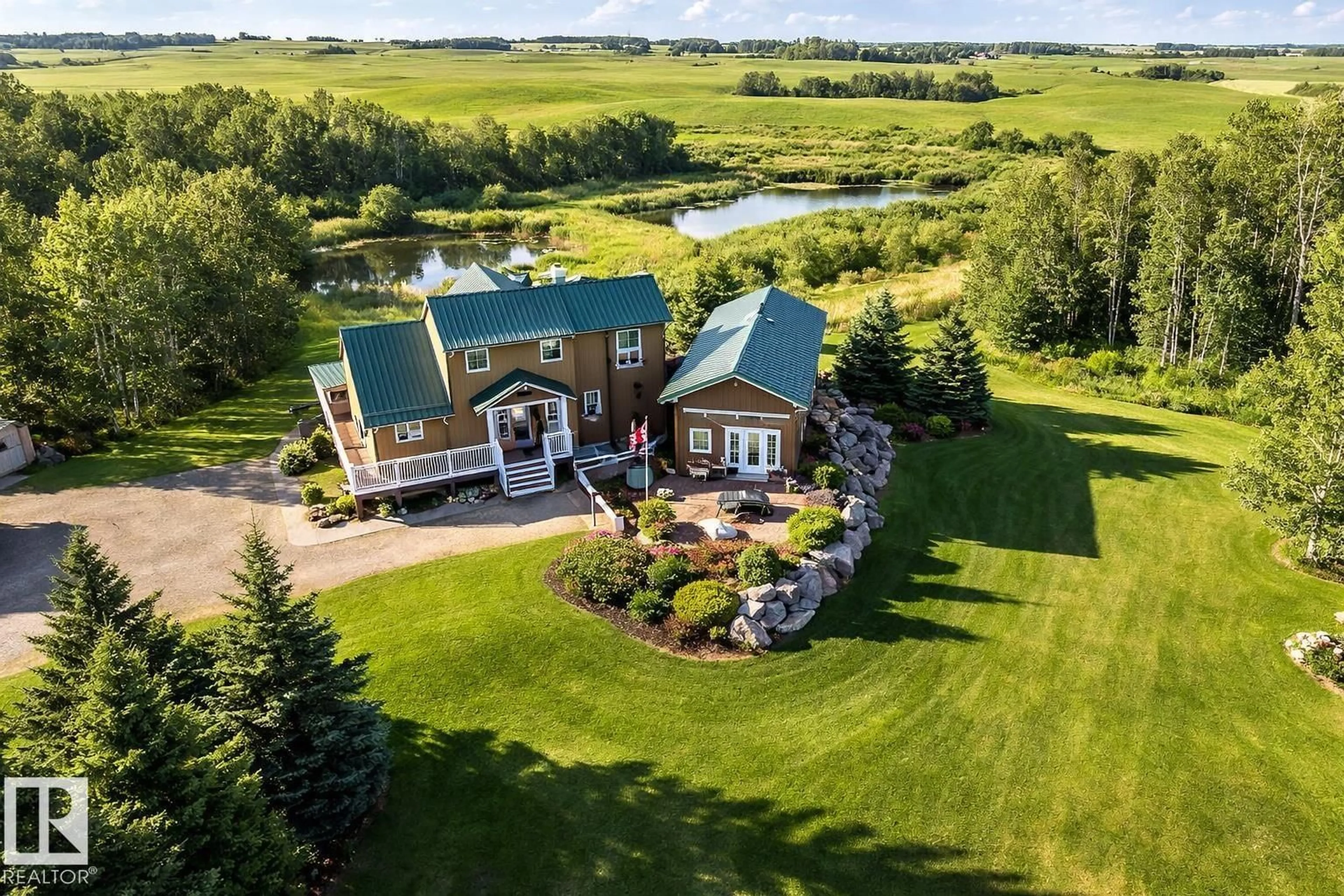 A pic from outside/outdoor area/front of a property/back of a property/a pic from drone, water/lake/river/ocean view for 120 50434 RGE RD 232, Rural Leduc County Alberta T4X0L1