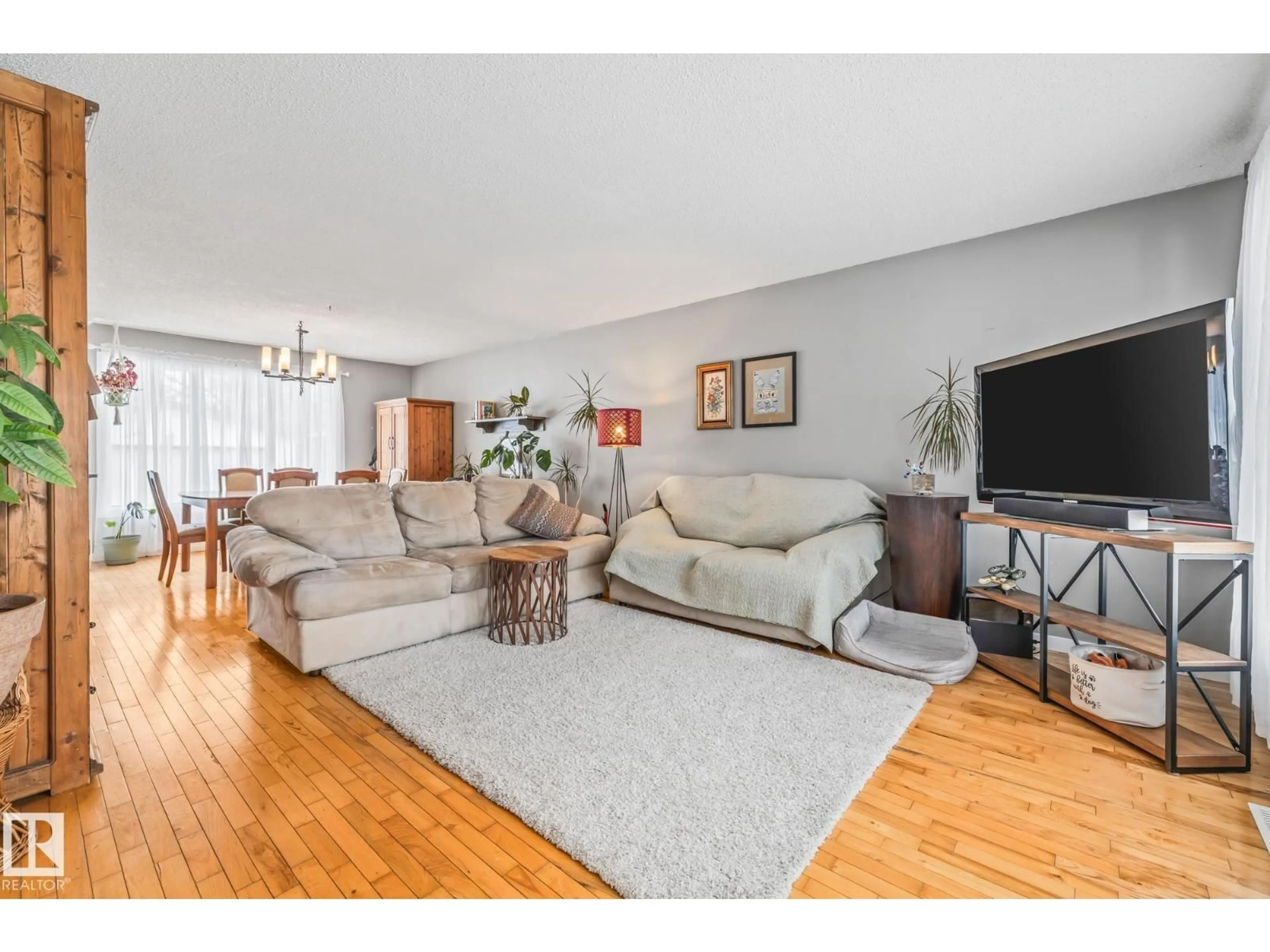 Living room with furniture, wood/laminate floor for 6811 FULTON DR, Edmonton Alberta T6A3V7