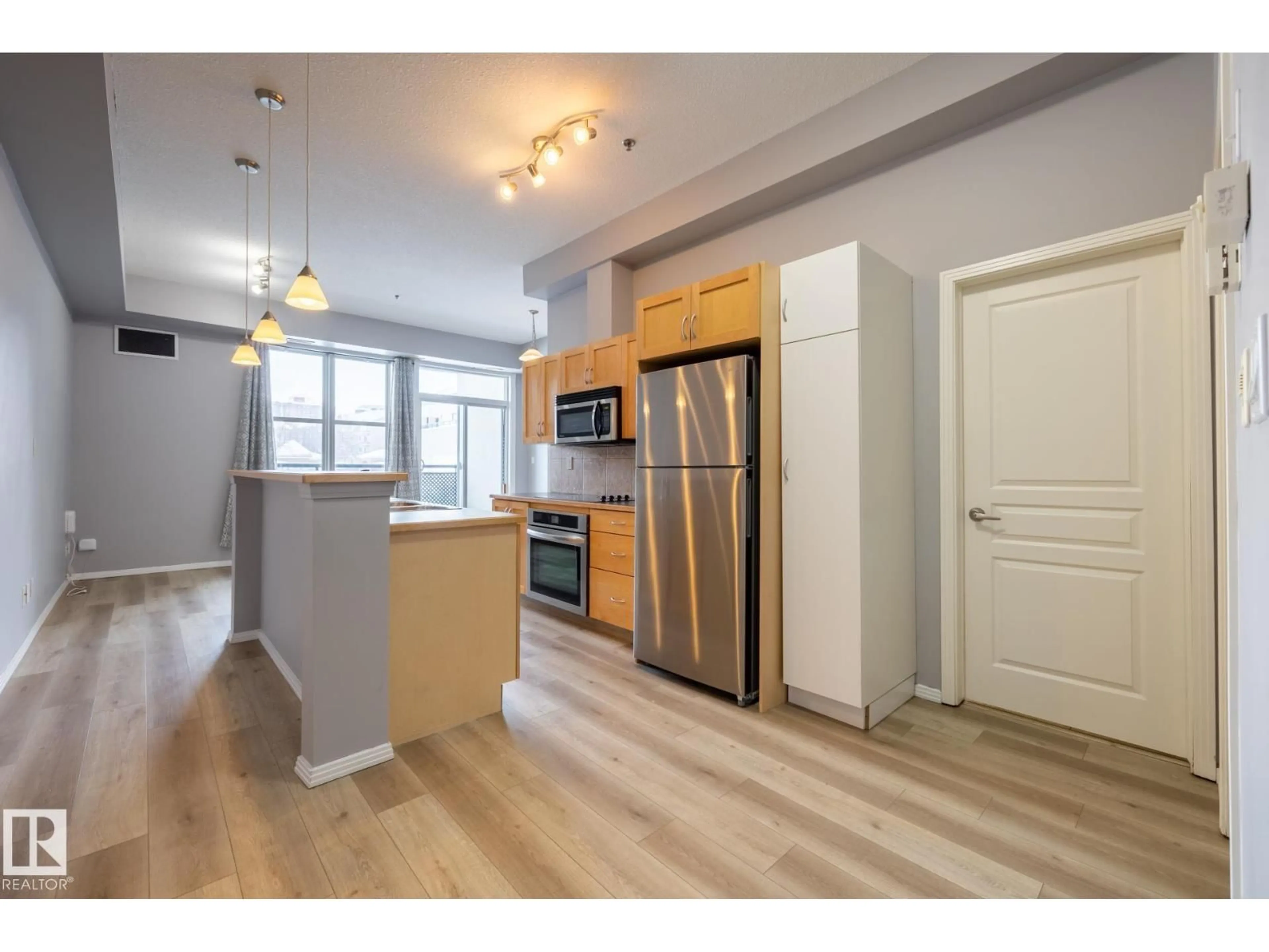 Open concept kitchen, wood/laminate floor for #210 - 10147 112 ST, Edmonton Alberta T5K1M1