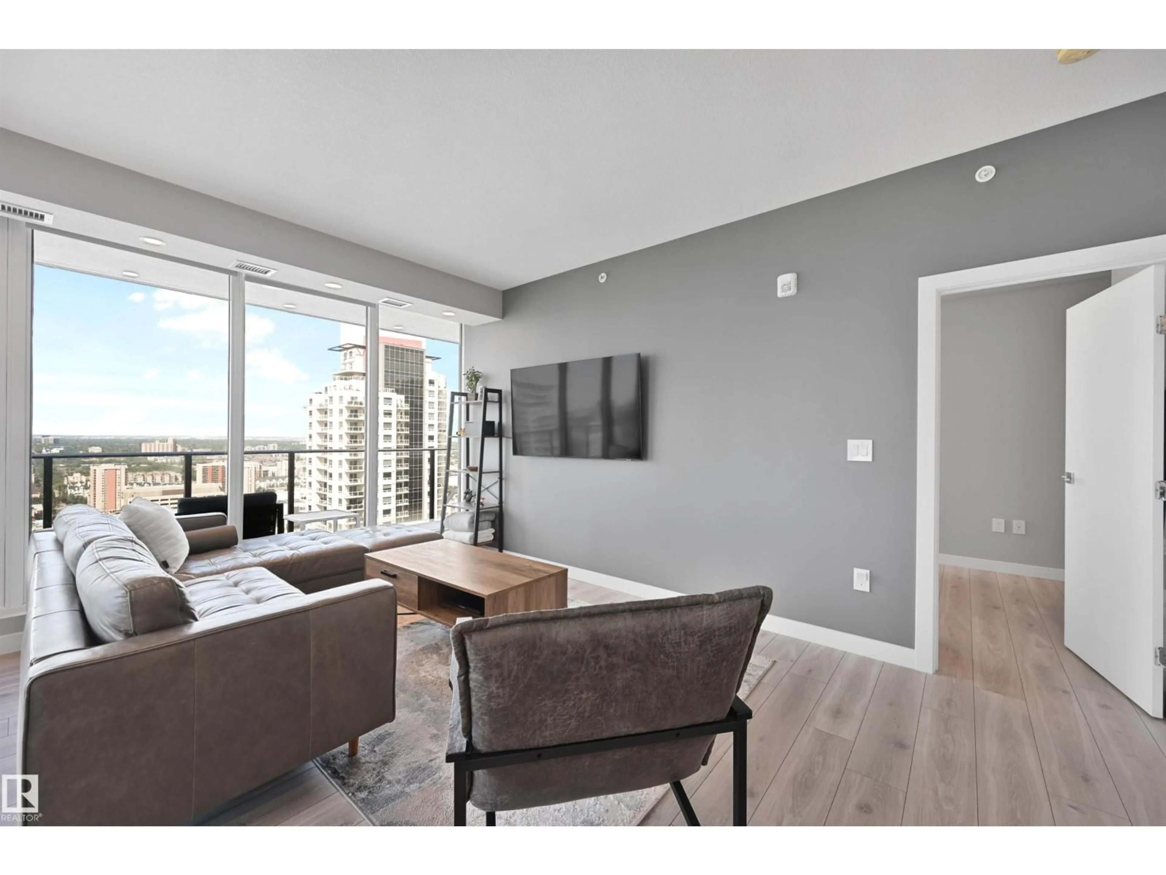 Living room with furniture, wood/laminate floor for 2701 10180 103 ST NW, Edmonton Alberta T5J0L1