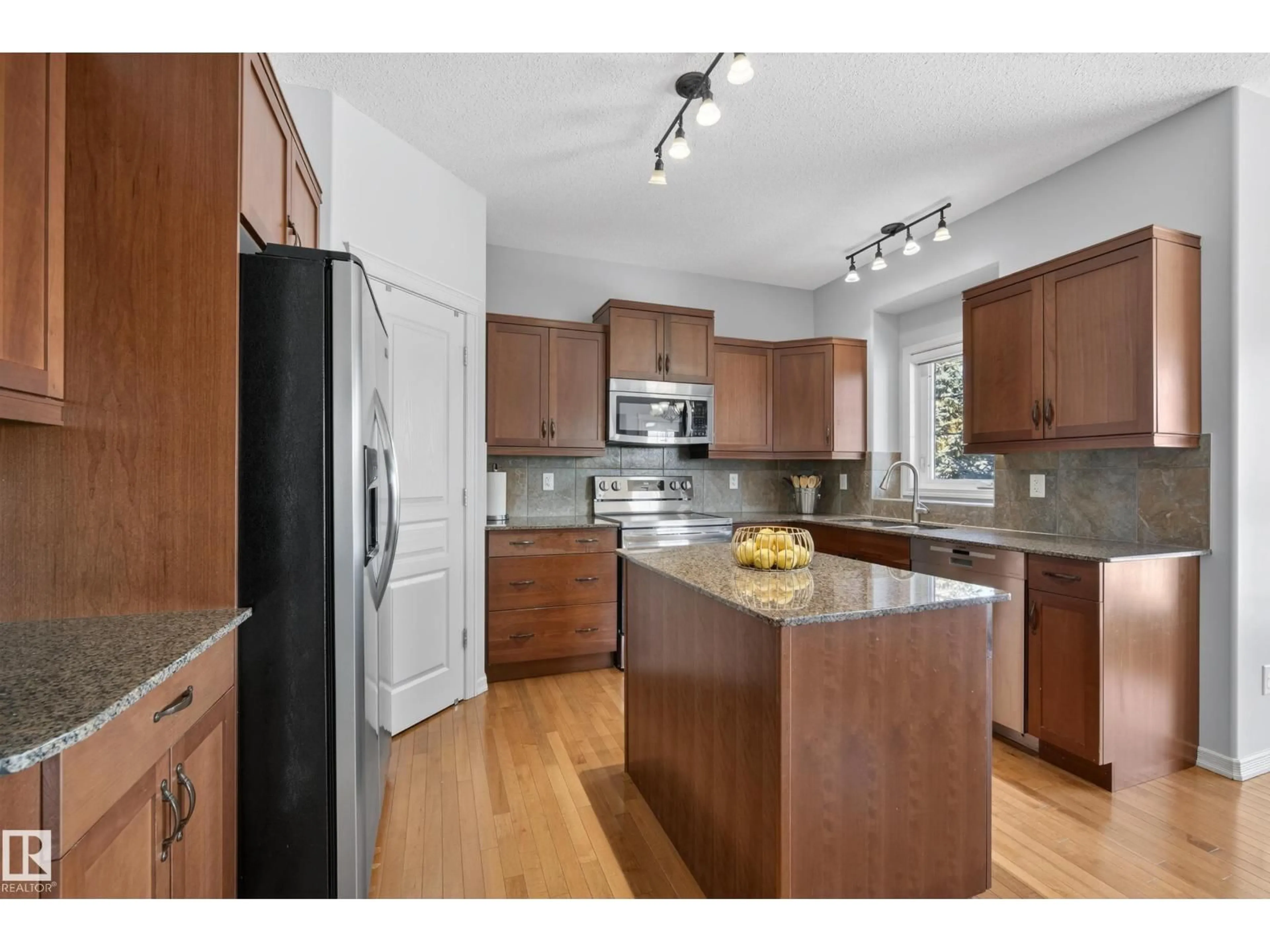 Open concept kitchen, wood/laminate floor for 20714 56A AV, Edmonton Alberta T6M0E7