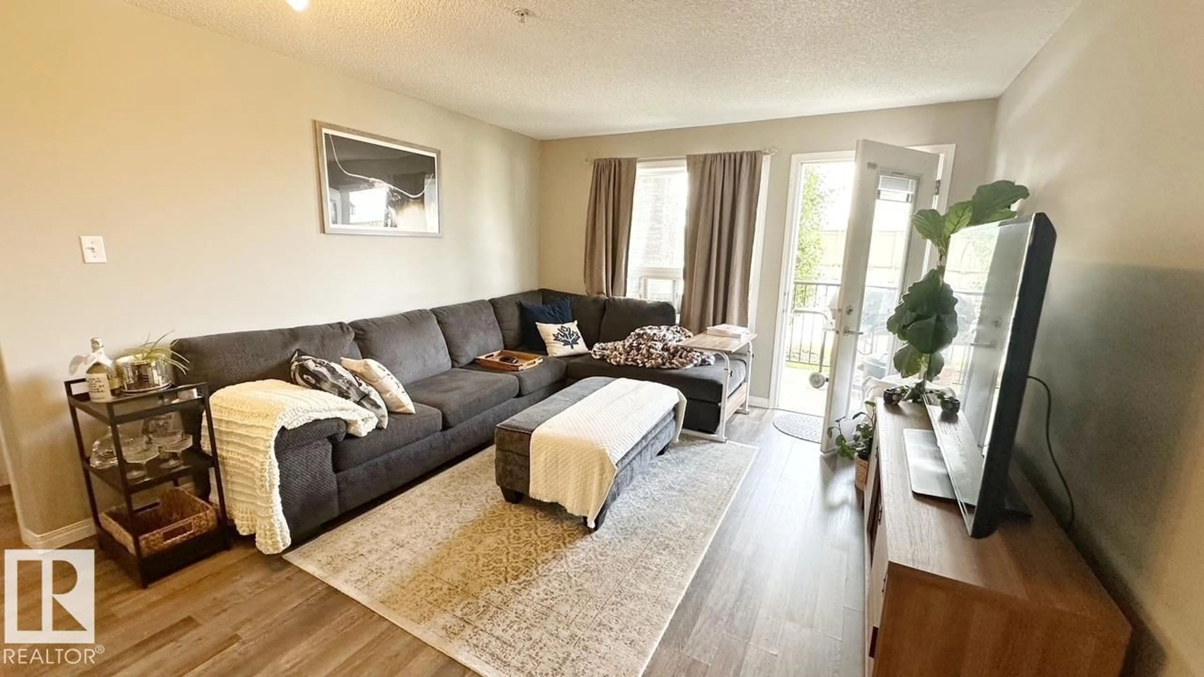 Living room with furniture, wood/laminate floor for 9363 - 1112 SIMPSON DR, Edmonton Alberta T6R0N2