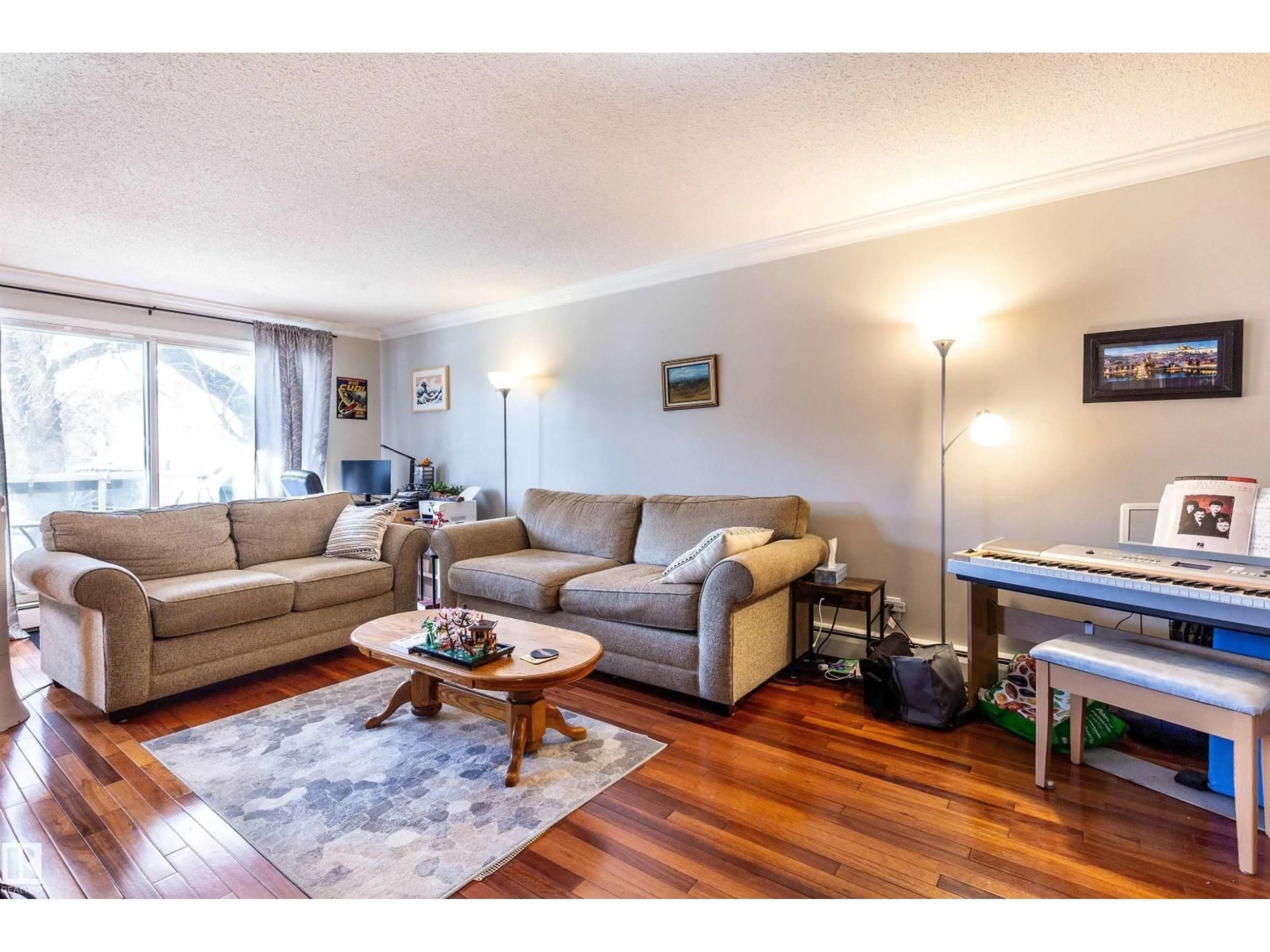 Living room with furniture, wood/laminate floor for 201 - 10720 84 AV, Edmonton Alberta T6E2H9