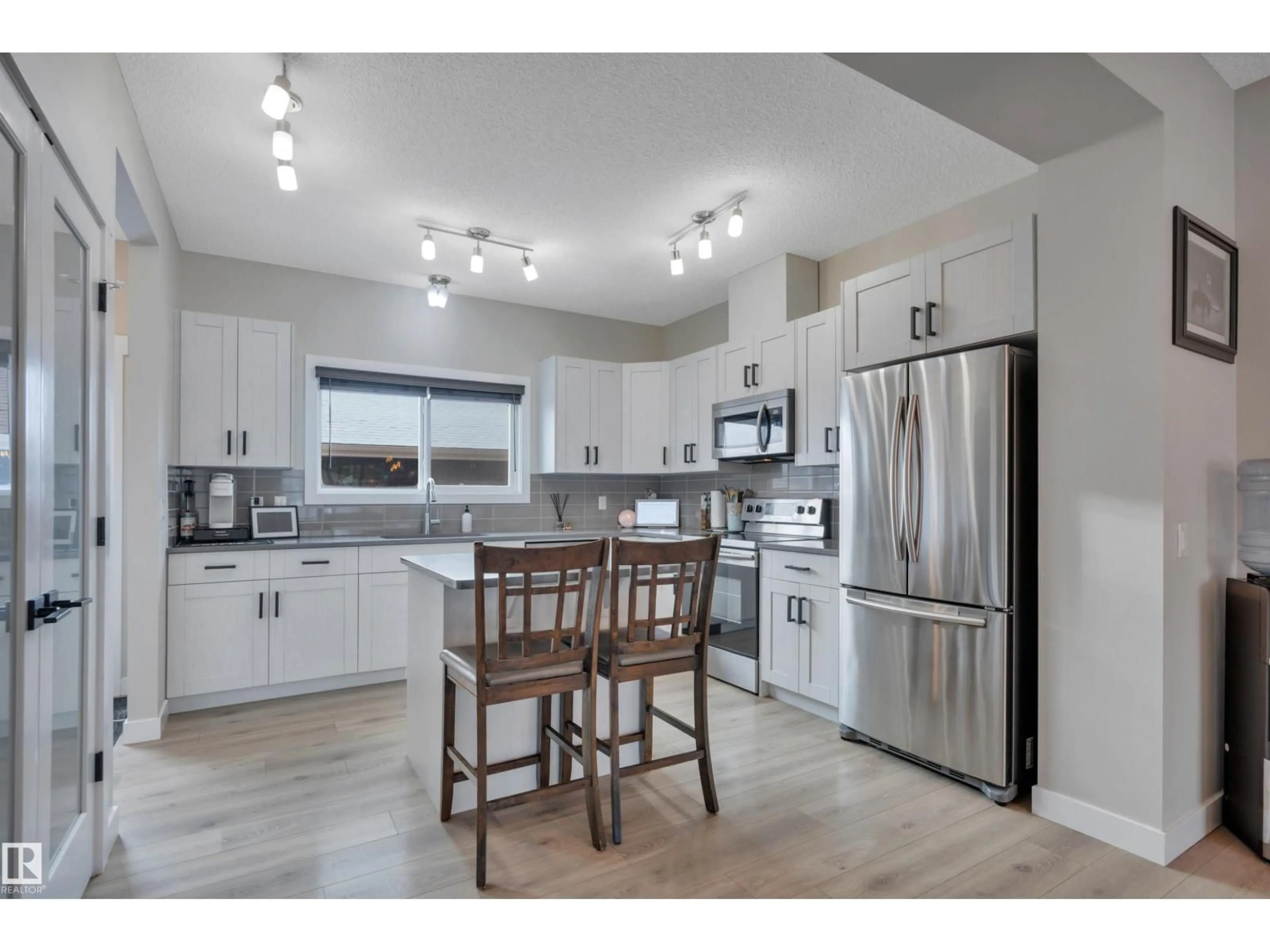 Open concept kitchen, wood/laminate floor for 8021 ORCHARDS GR, Edmonton Alberta T6X2L5