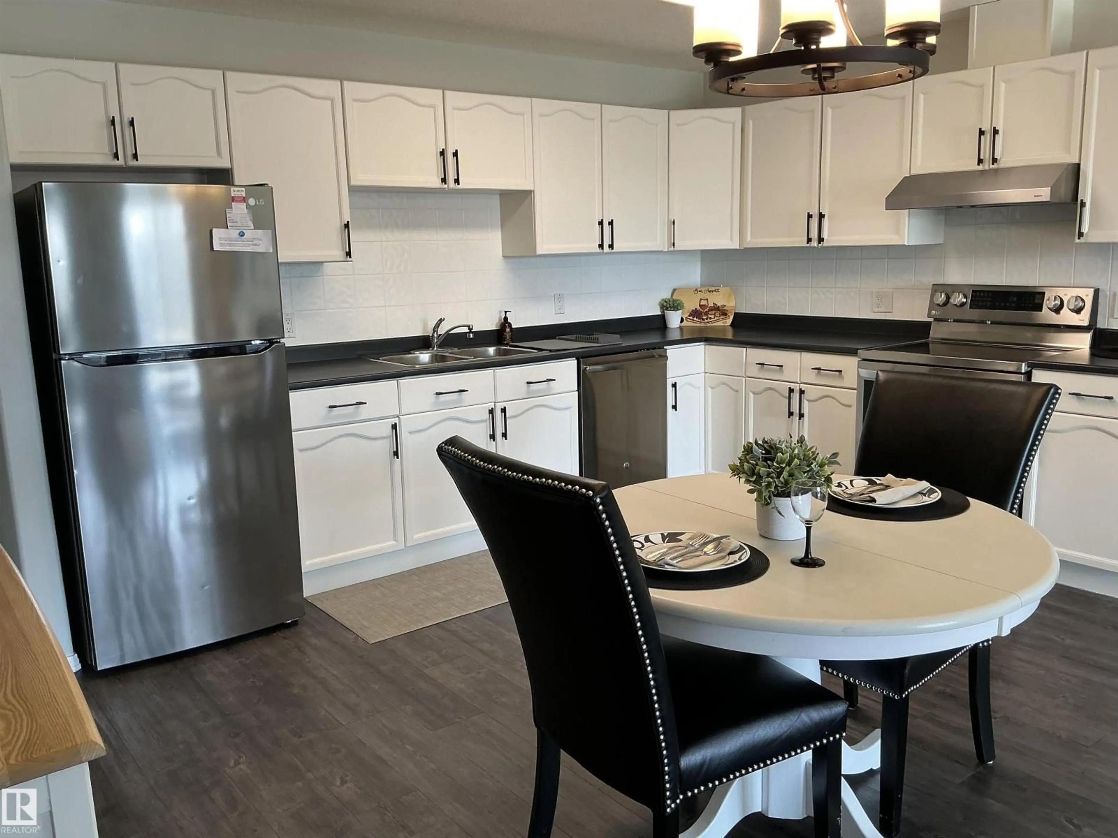 Open concept kitchen, wood/laminate floor for #207 - 592 HOOKE RD, Edmonton Alberta T5A5H2