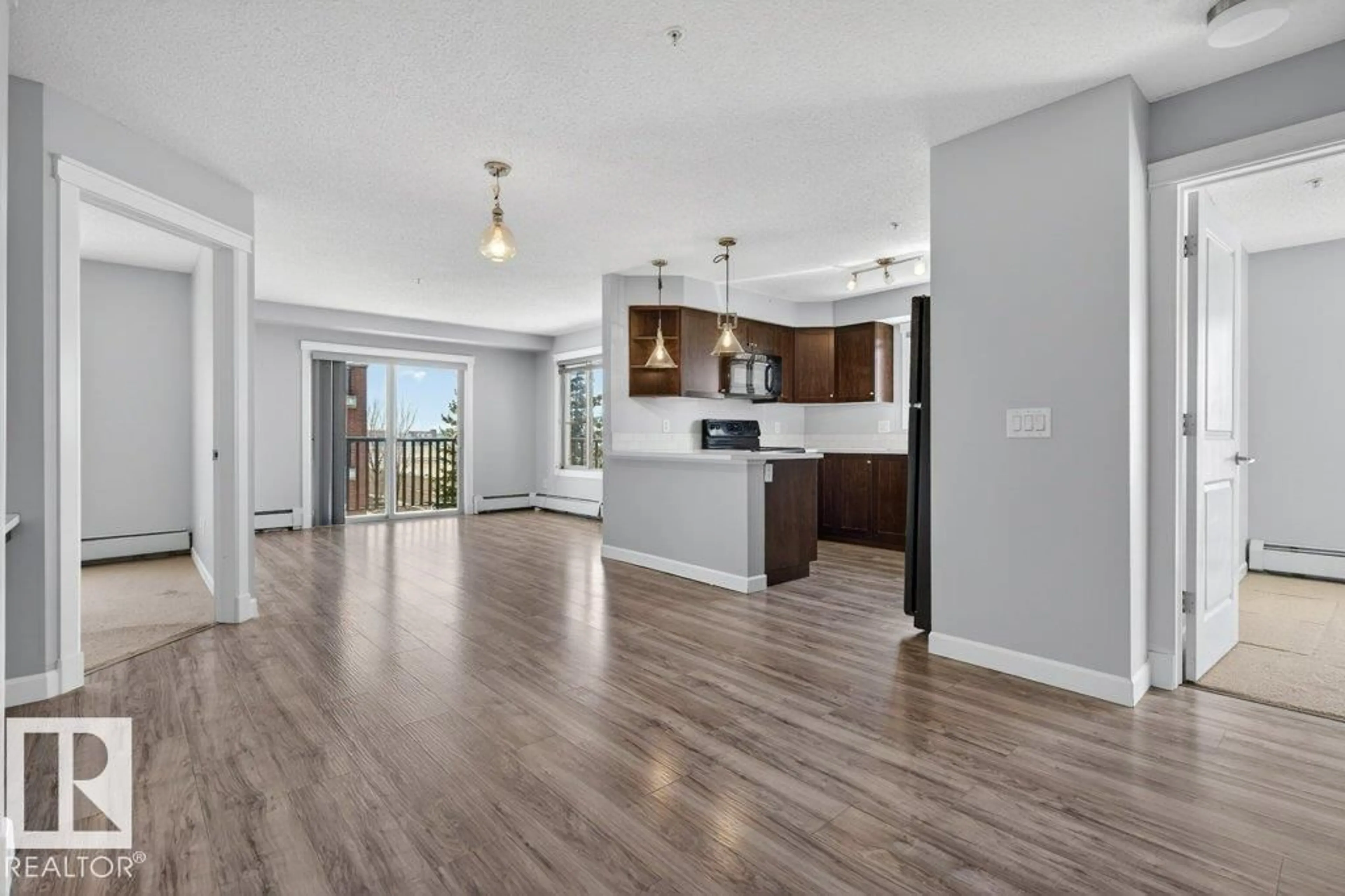 Open concept kitchen, wood/laminate floor for #206 - 3719 WHITELAW LN, Edmonton Alberta T6W2C3