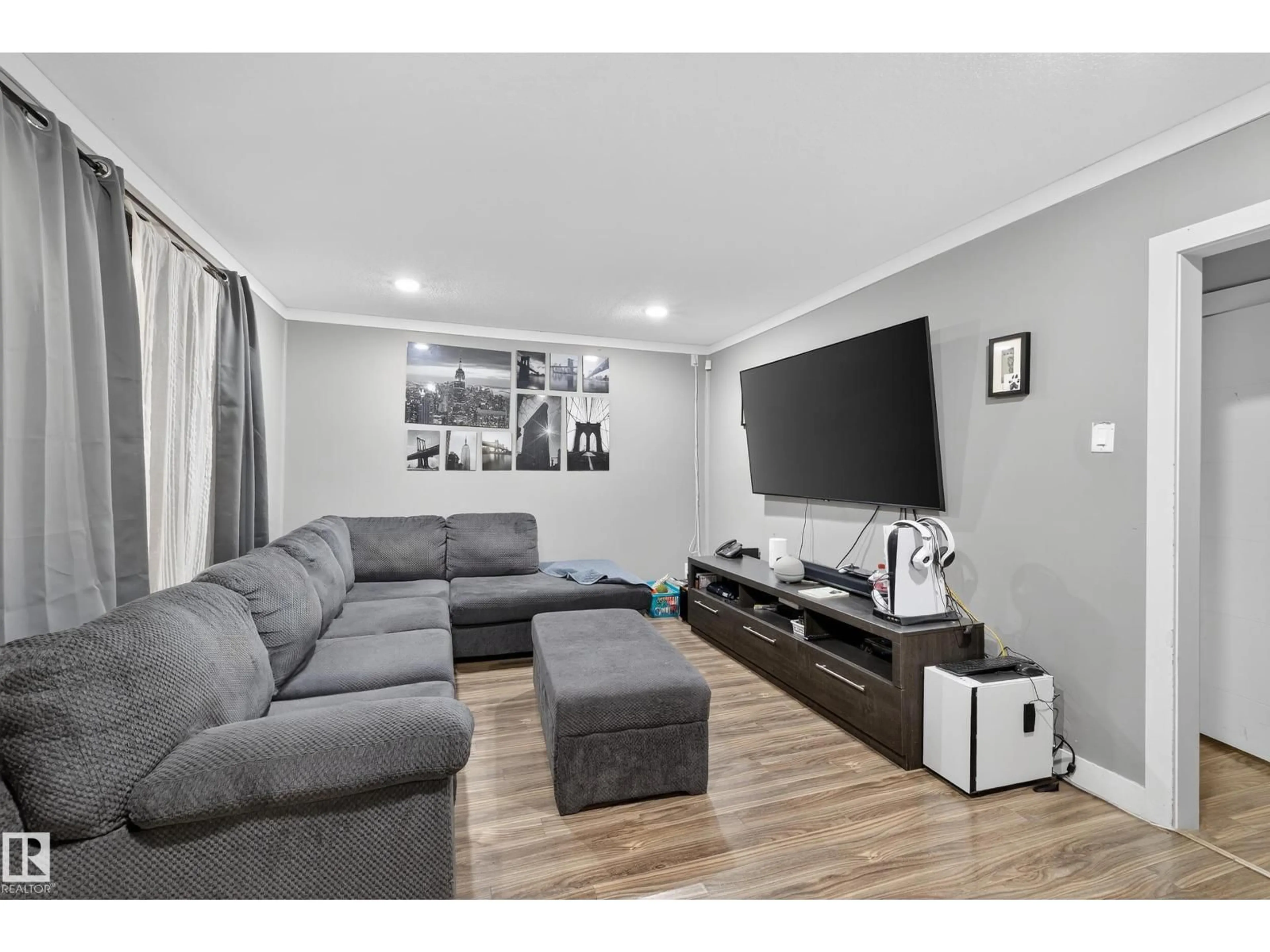 Living room with furniture, wood/laminate floor for NW - 6014 120 AV, Edmonton Alberta T5W1L7