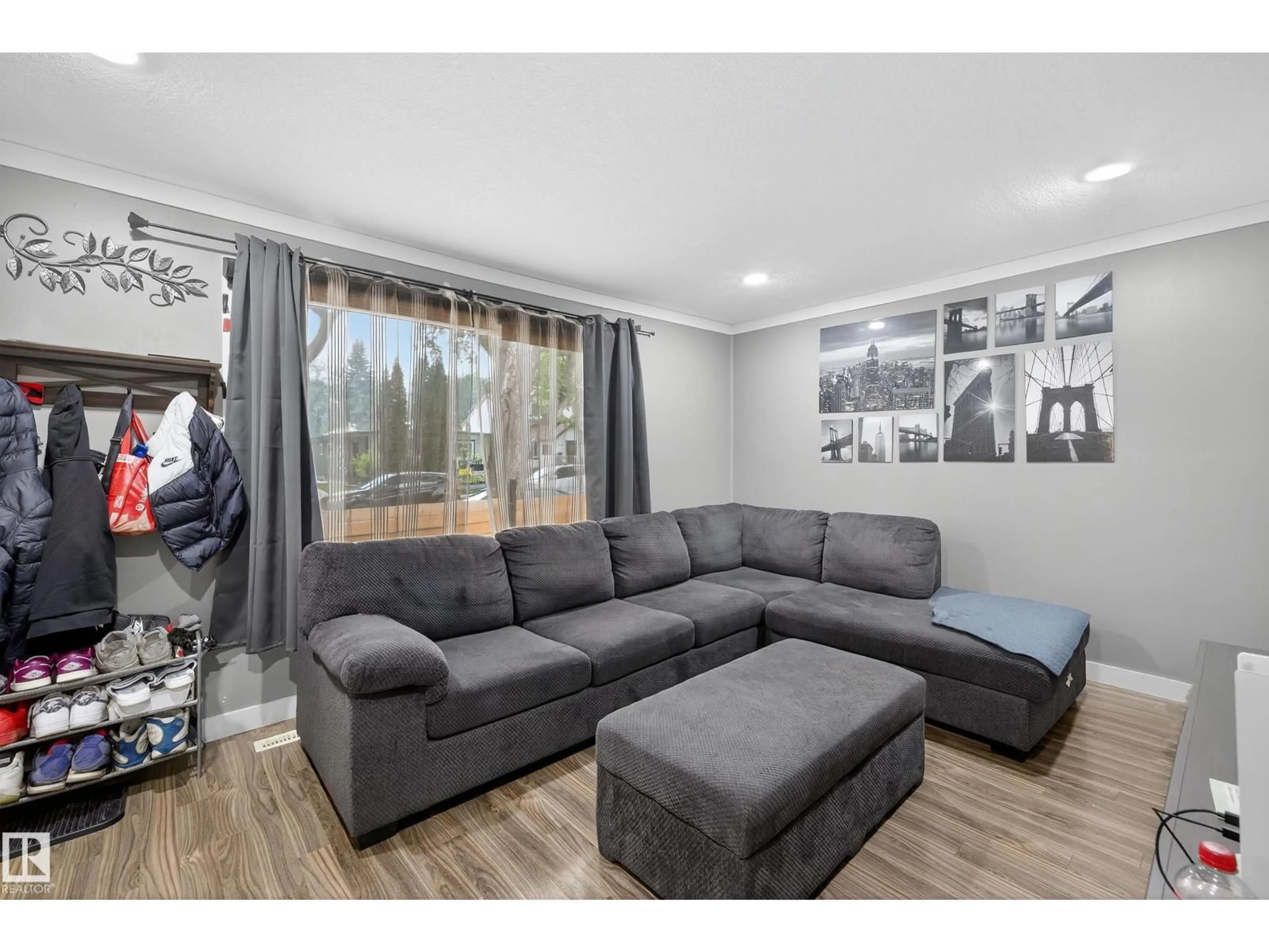 Living room with furniture, wood/laminate floor for NW - 6014 120 AV, Edmonton Alberta T5W1L7