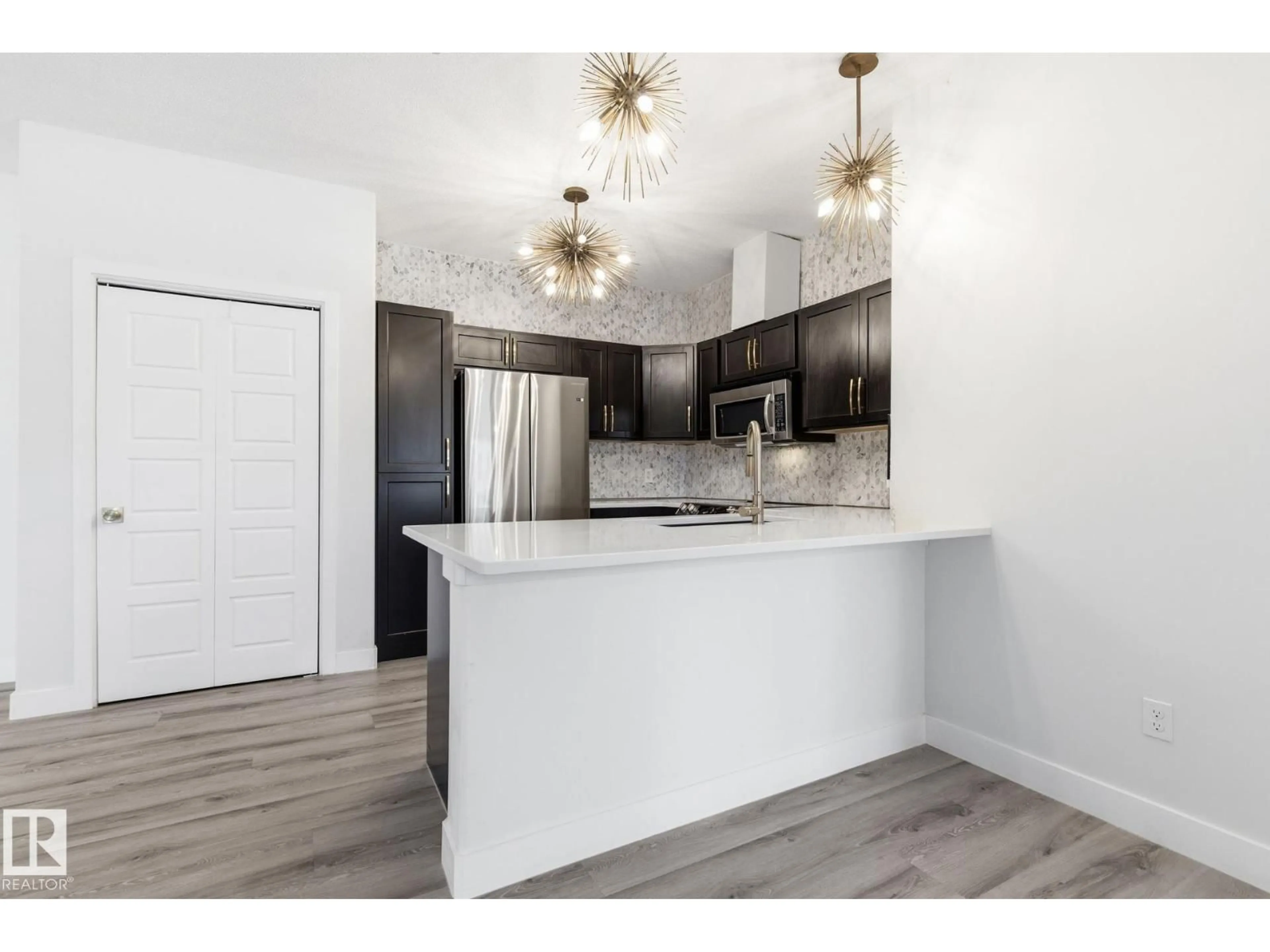 Open concept kitchen, wood/laminate floor for #105 - 304 AMBLESIDE LINK LI, Edmonton Alberta T6W0V2