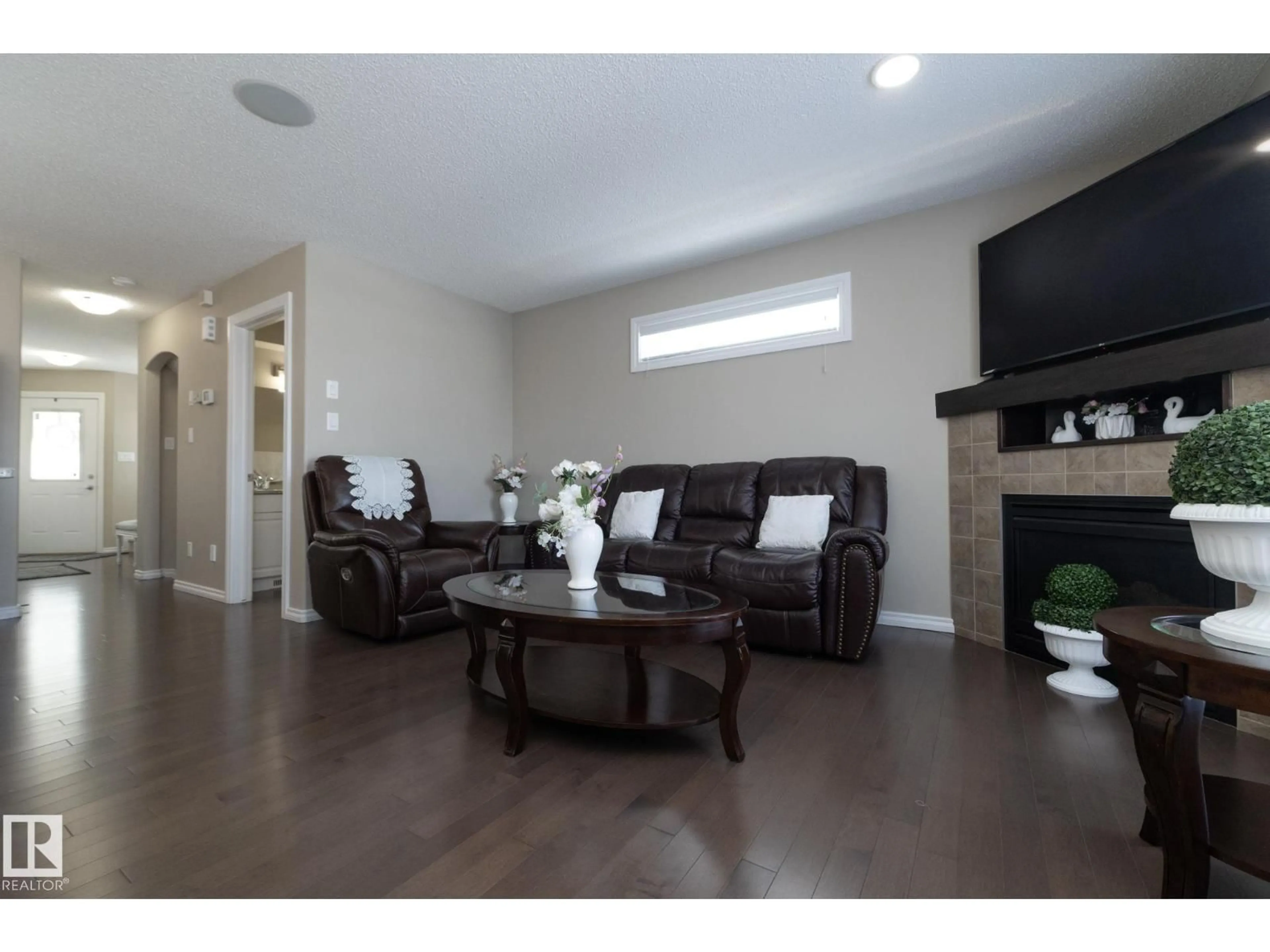 Living room with furniture, wood/laminate floor for 132 KIRPATRICK WY, Leduc Alberta T9E0Z2