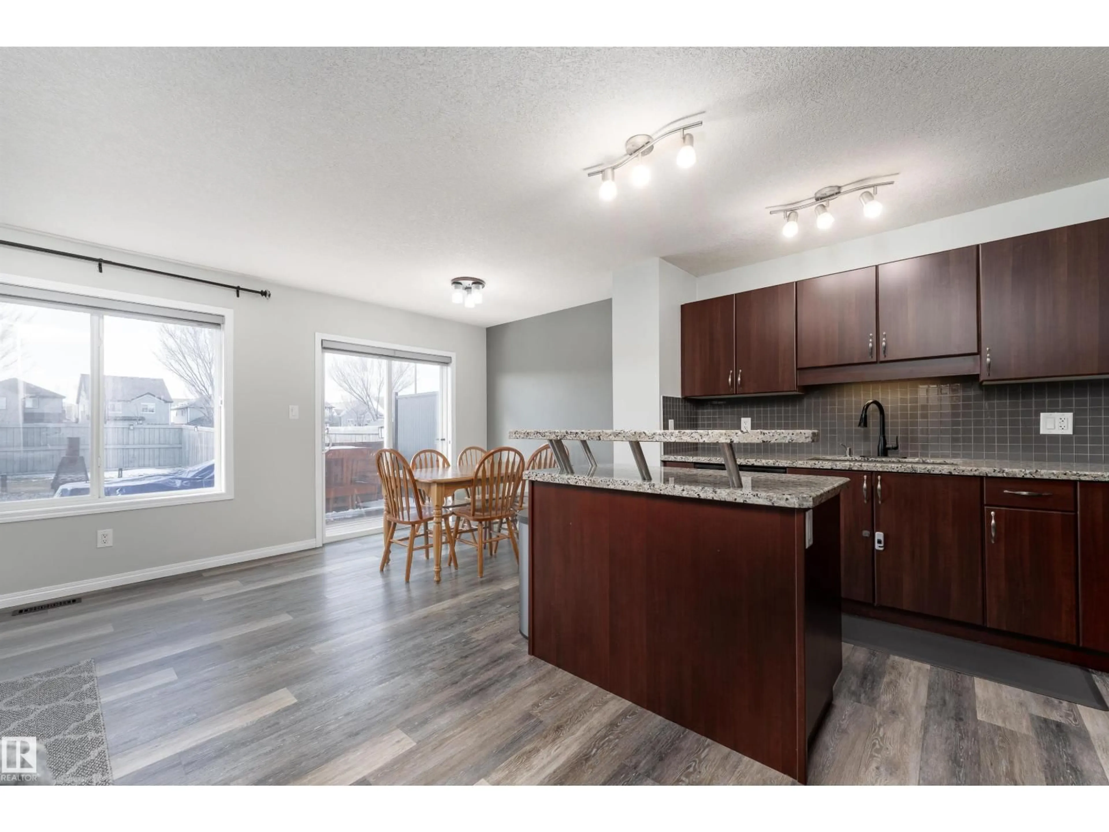 Open concept kitchen, wood/laminate floor for 5911 8 AV SW, Edmonton Alberta T6X0G5