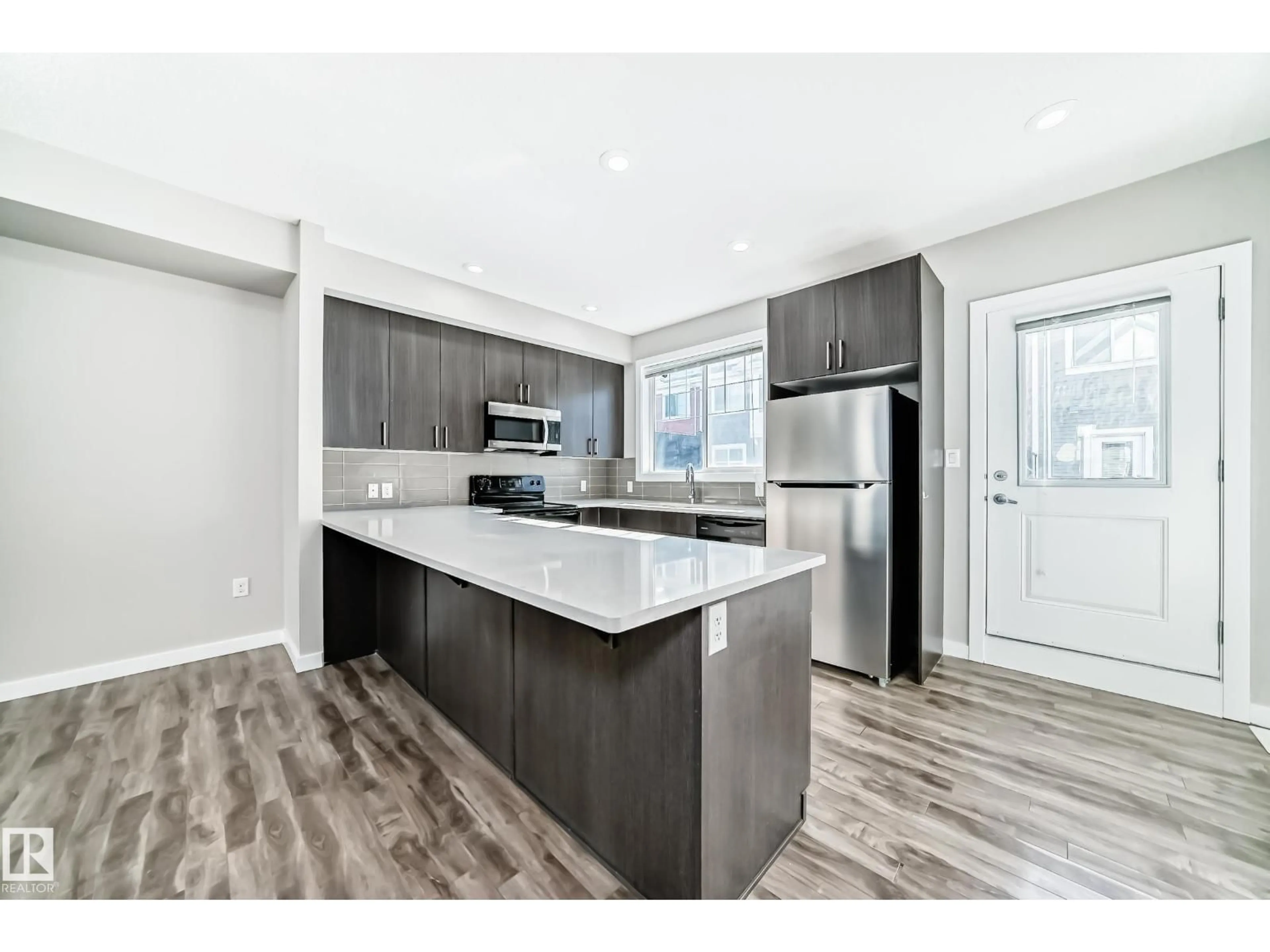 Open concept kitchen, wood/laminate floor for #75 - 2803 JAMES MOWATT TR, Edmonton Alberta T6W2P5