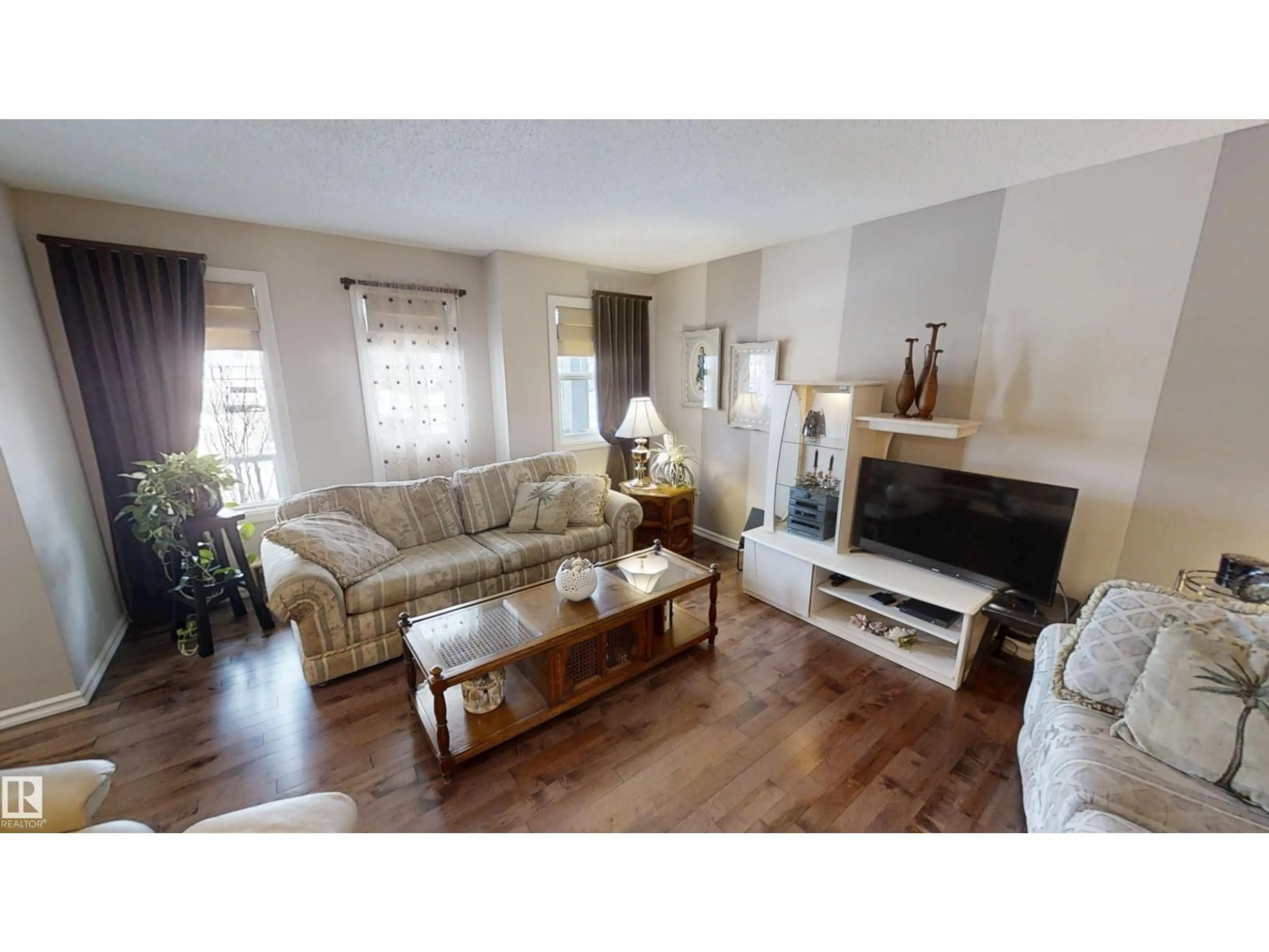 Living room with furniture, wood/laminate floor for 8627 173 AV, Edmonton Alberta T5Z3W4
