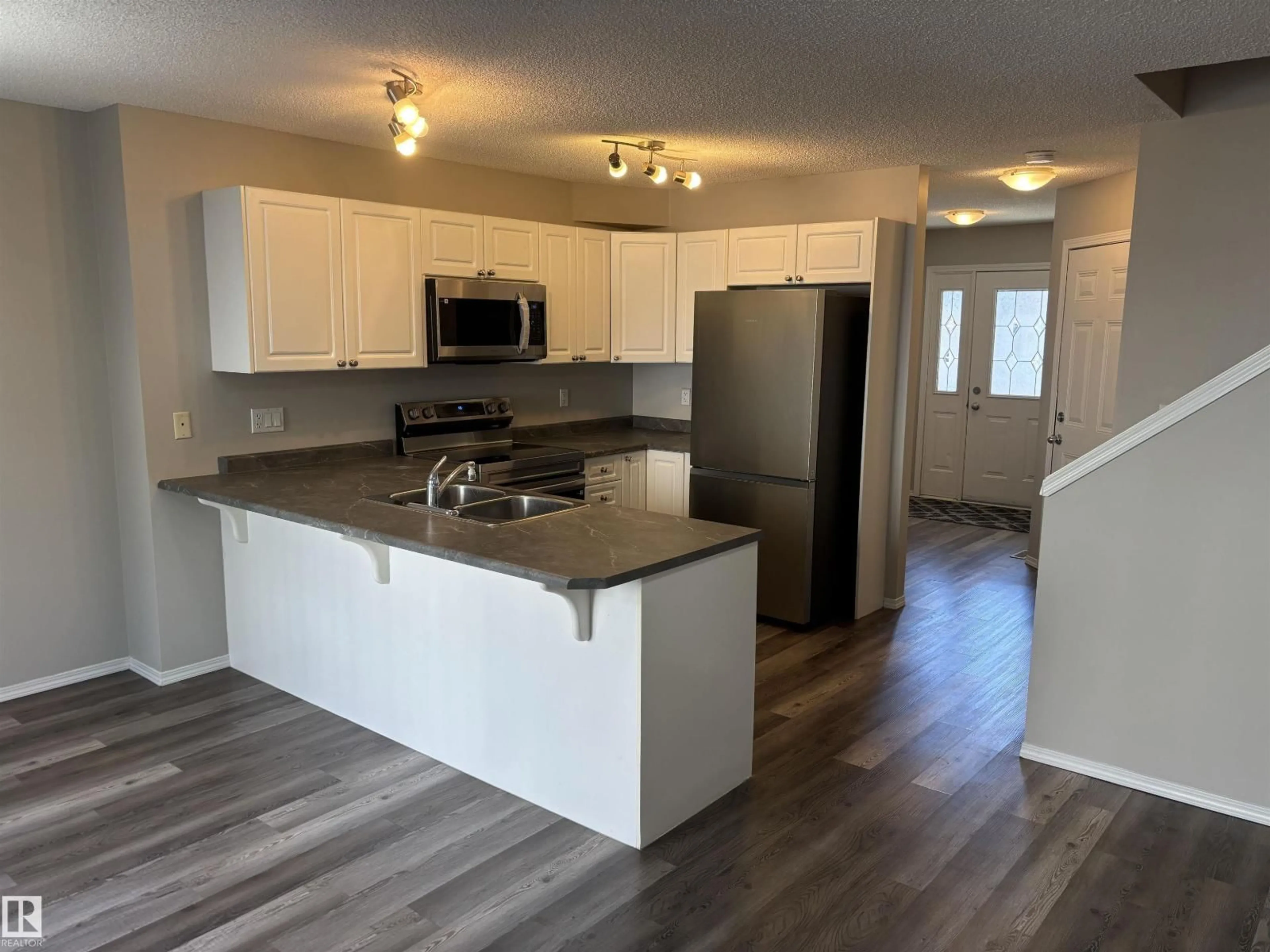 Open concept kitchen, wood/laminate floor for 133 - 5001 62 ST, Beaumont Alberta T4X0C7