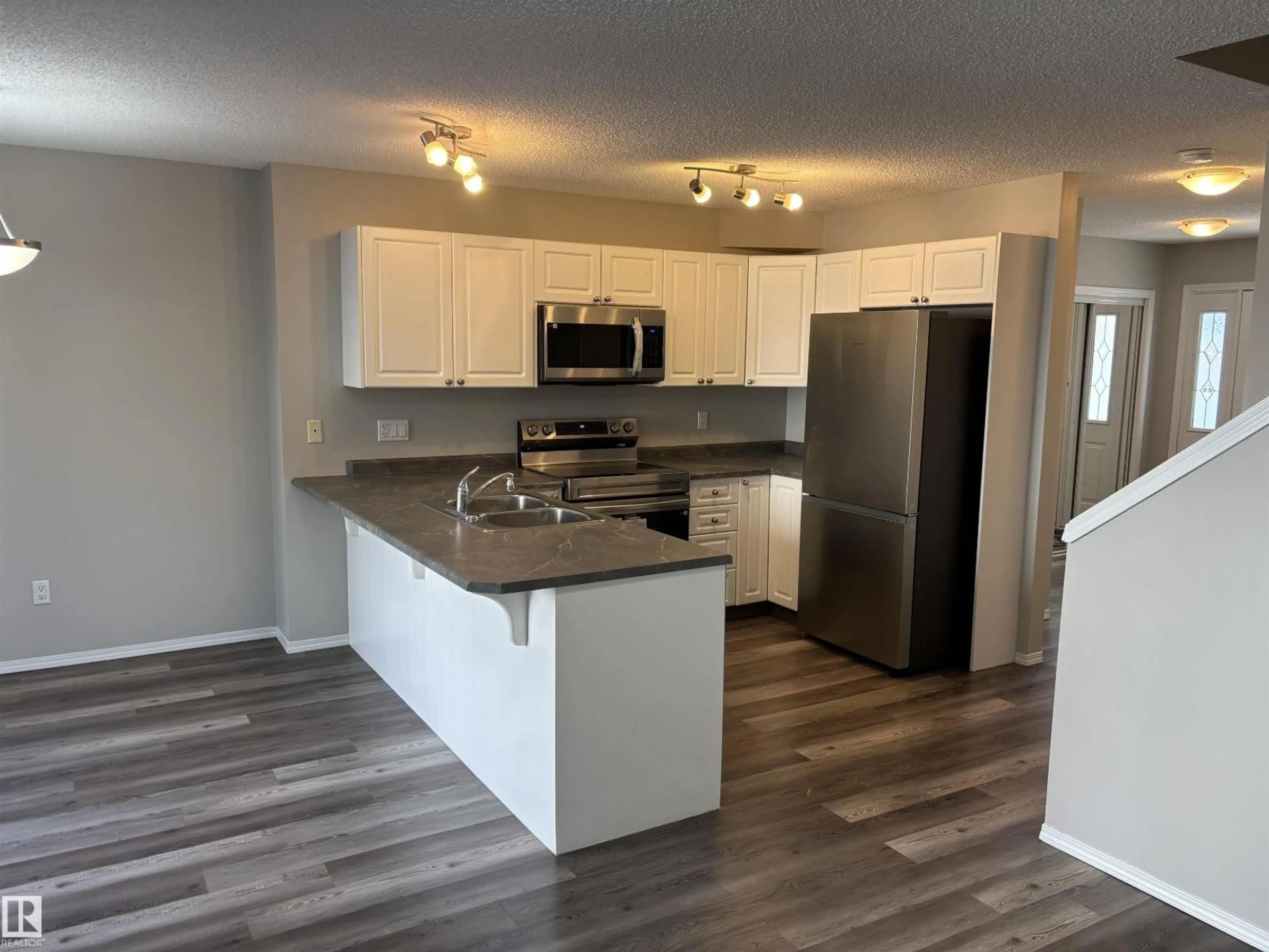 Open concept kitchen, wood/laminate floor for 133 - 5001 62 ST, Beaumont Alberta T4X0C7