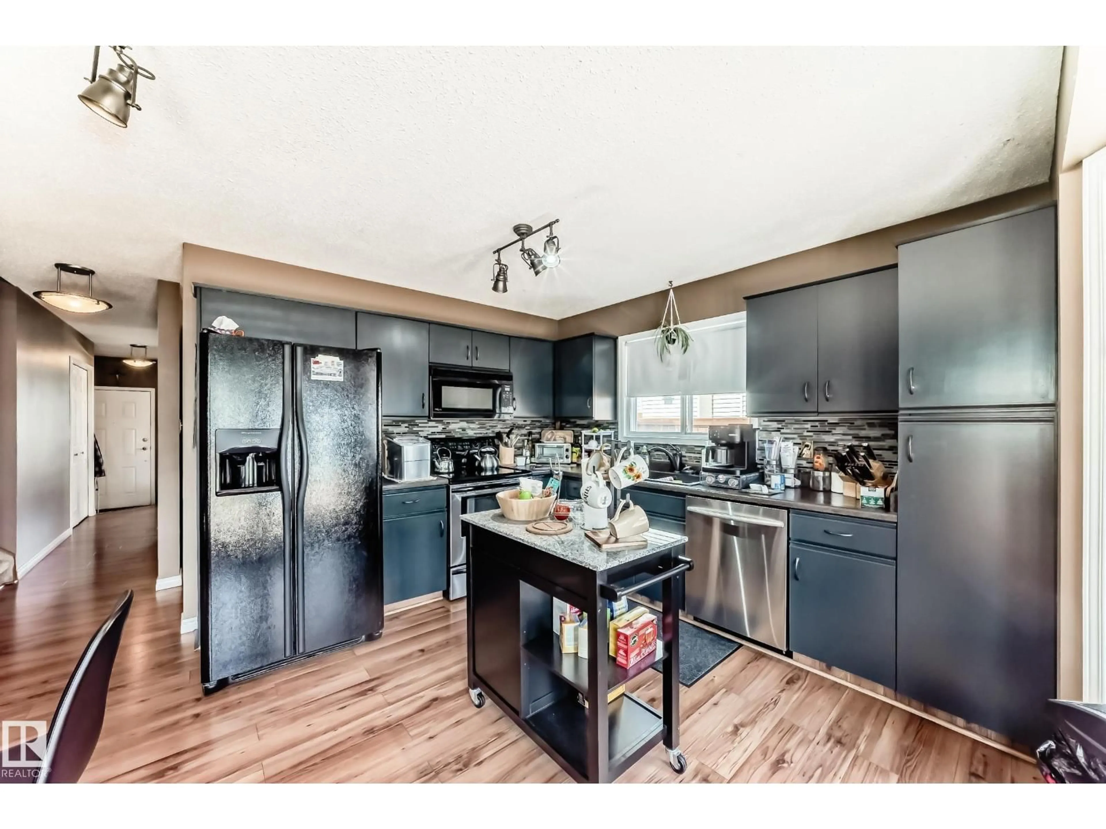 Open concept kitchen, wood/laminate floor for 9845 184 ST, Edmonton Alberta T5T4L5