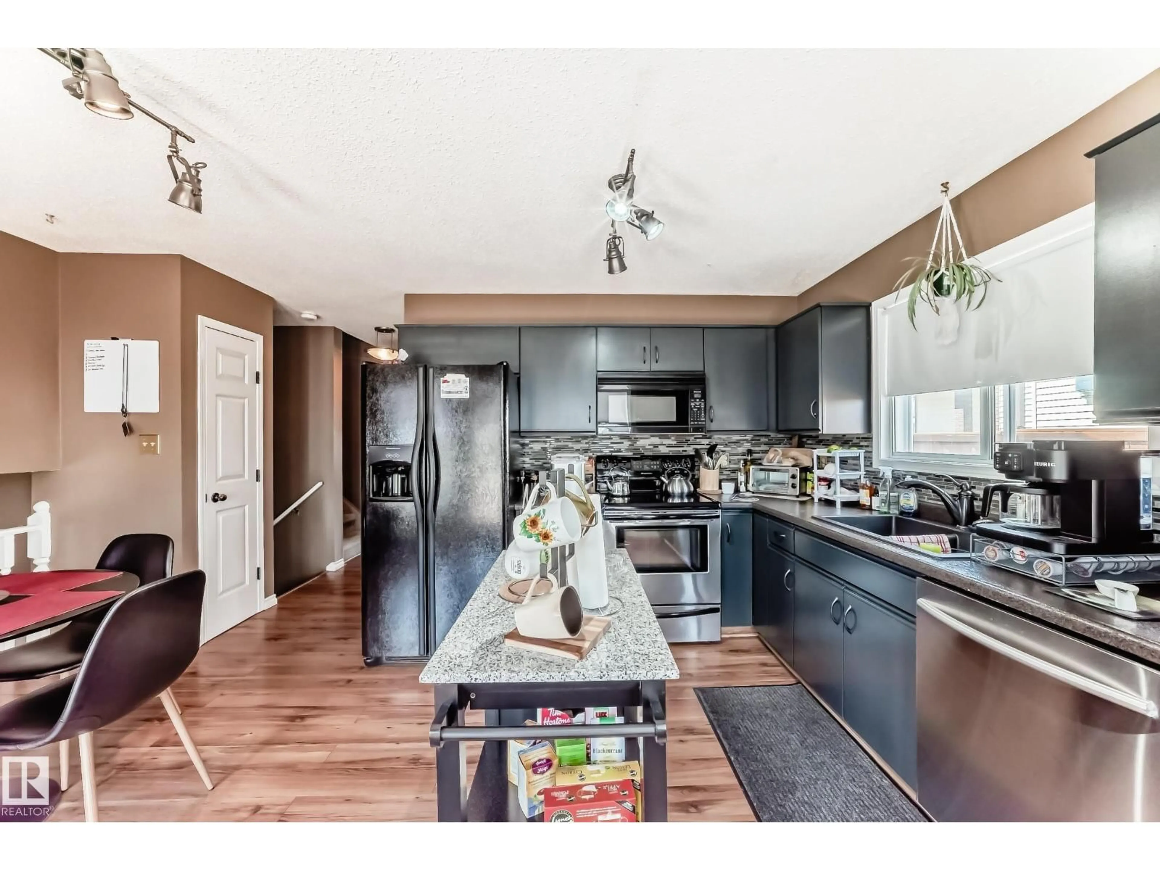 Open concept kitchen, wood/laminate floor for 9845 184 ST, Edmonton Alberta T5T4L5