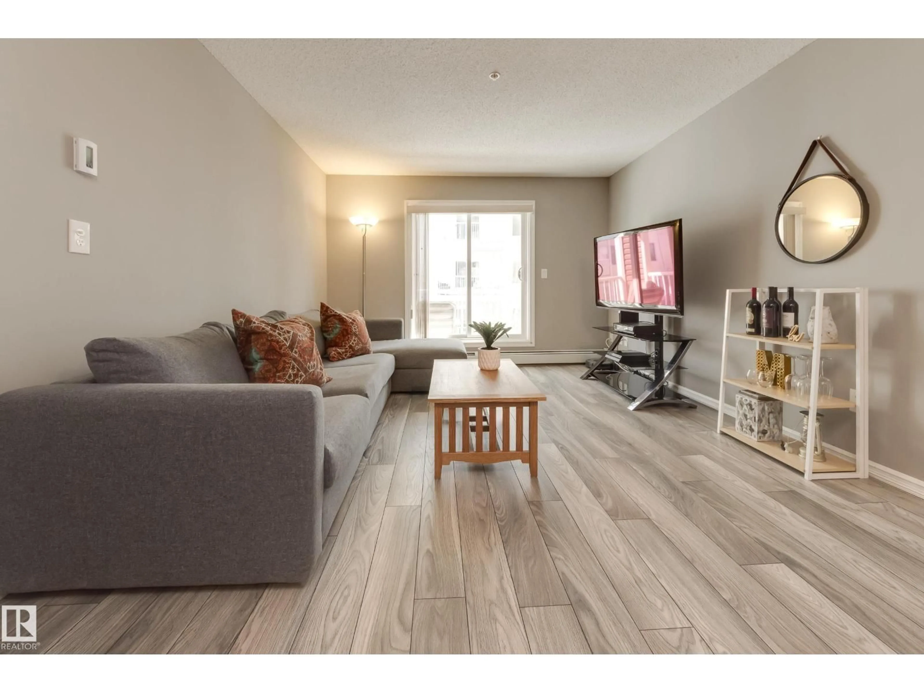 Living room with furniture, wood/laminate floor for #213 - 4403 23 ST NW, Edmonton Alberta T6T0E4