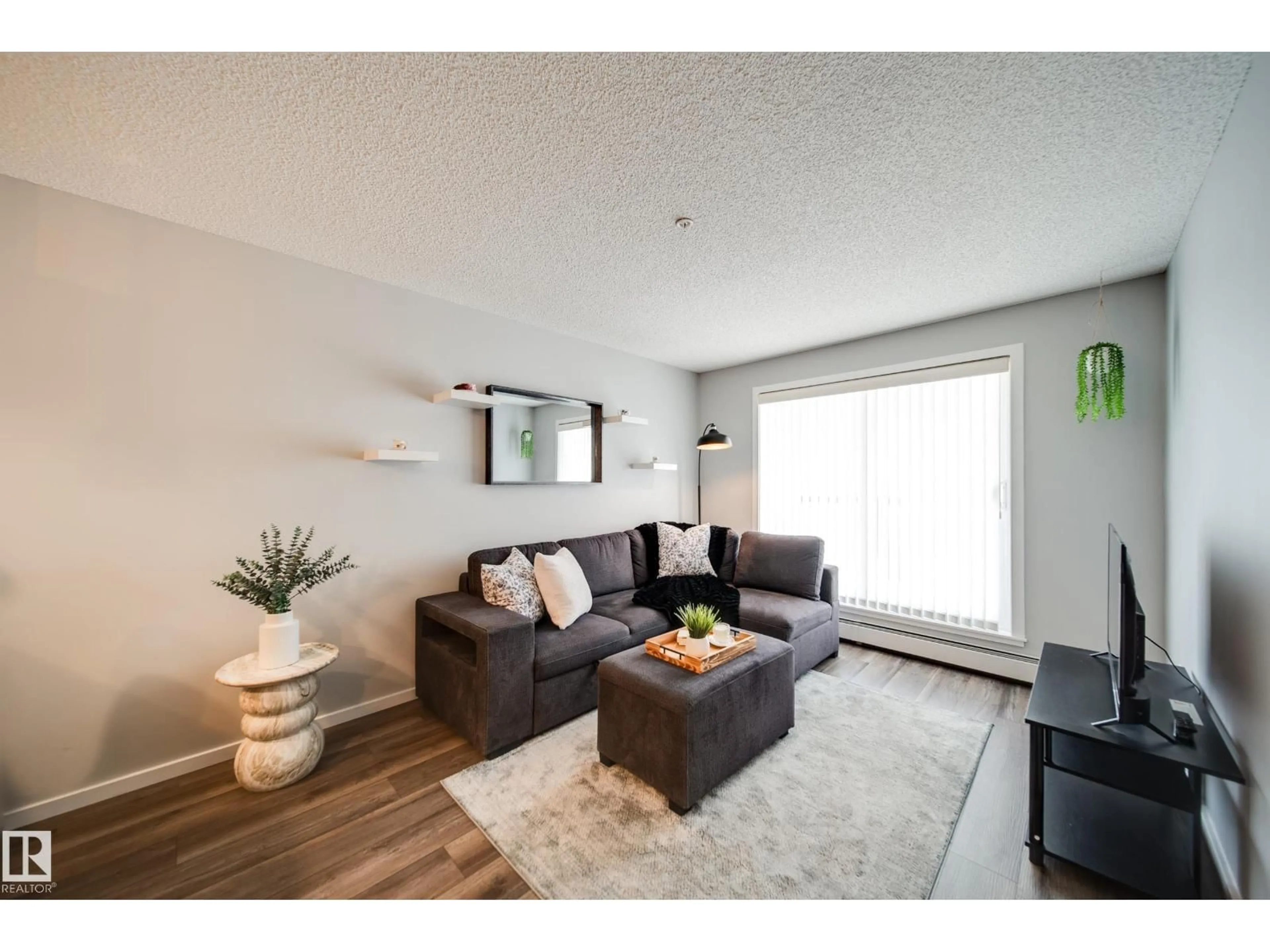 Living room with furniture, wood/laminate floor for #346 - 1196 HYNDMAN RD, Edmonton Alberta T5A0X8