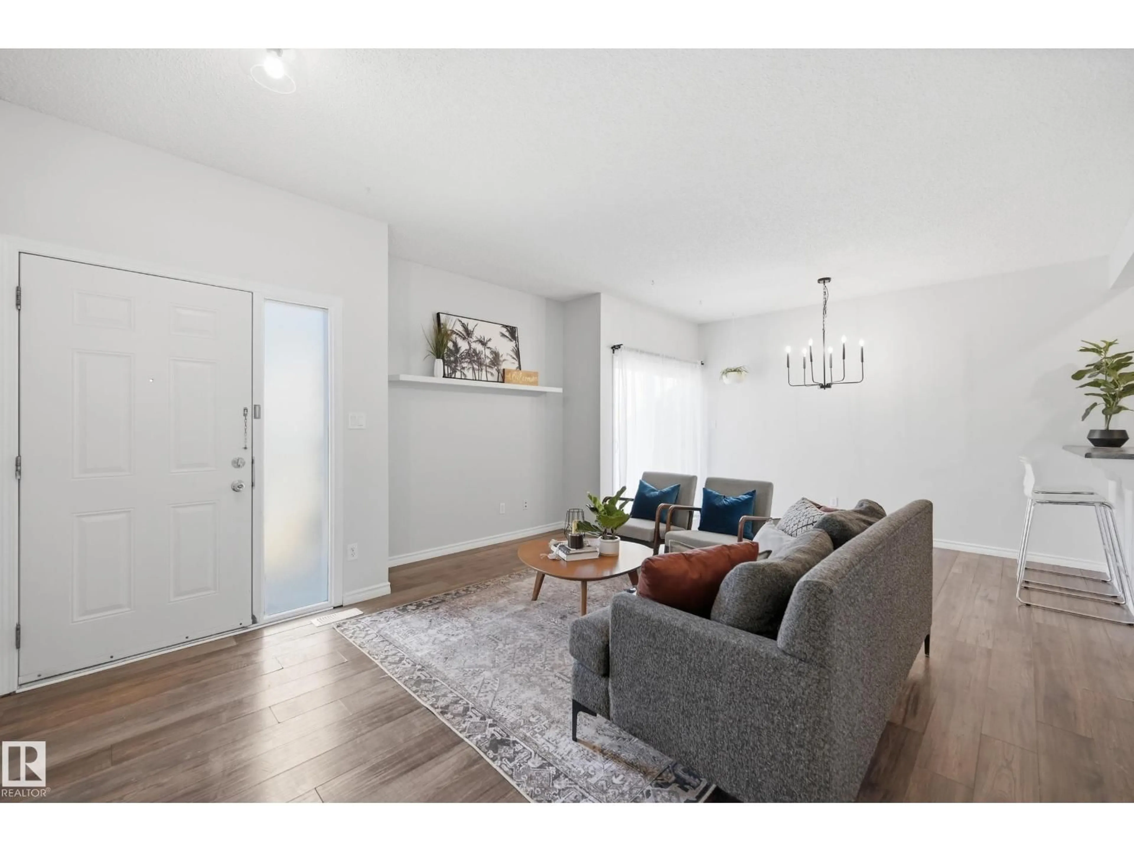 Living room with furniture, wood/laminate floor for 111 - 3040 SPENCE WD, Edmonton Alberta T6X1N7