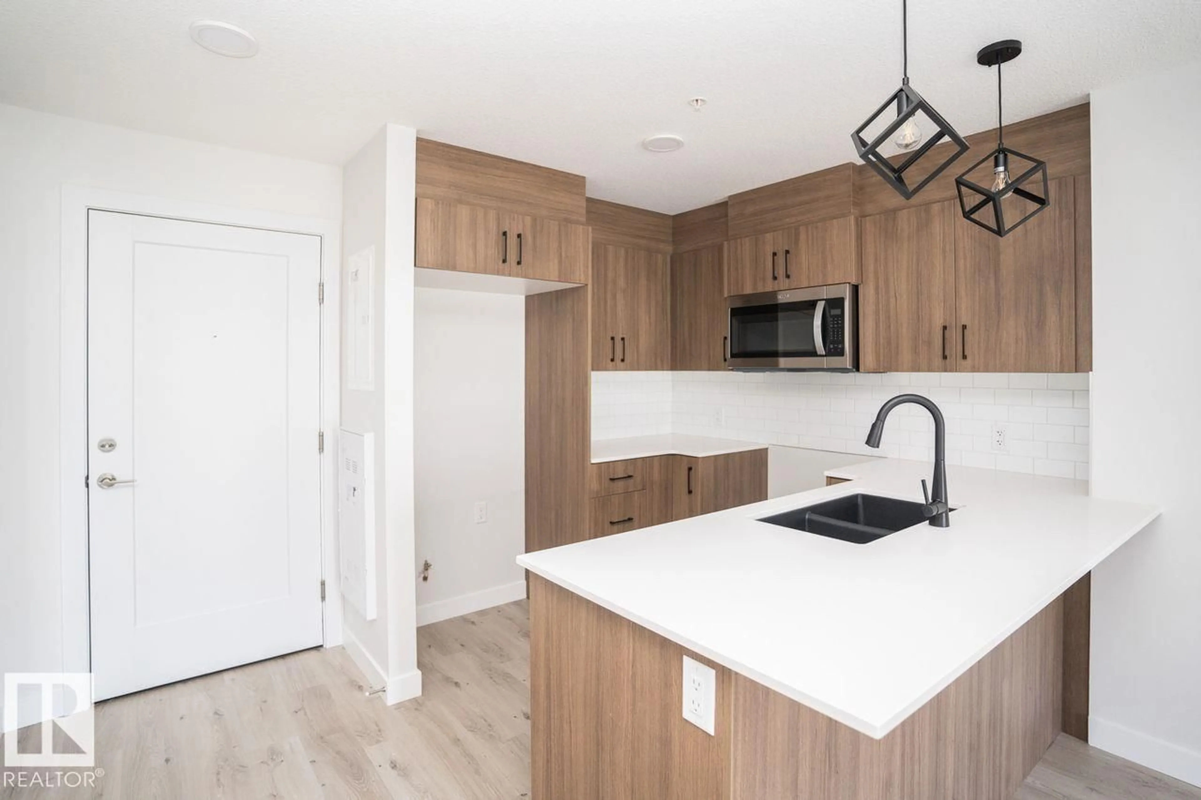 Open concept kitchen, wood/laminate floor for #204 - 2225 44 AV NW, Edmonton Alberta T6T0W5
