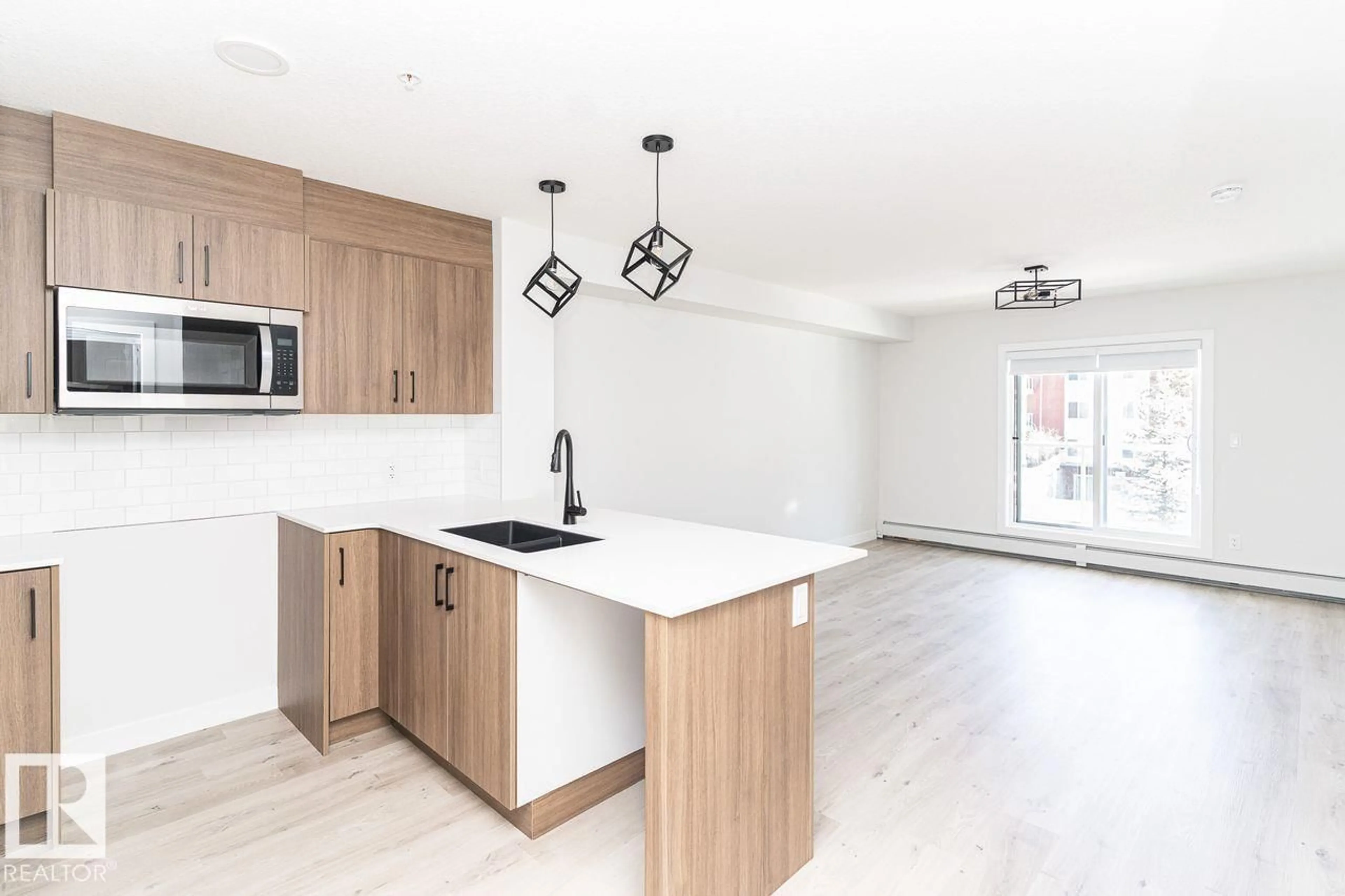 Open concept kitchen, wood/laminate floor for #204 - 2225 44 AV NW, Edmonton Alberta T6T0W5