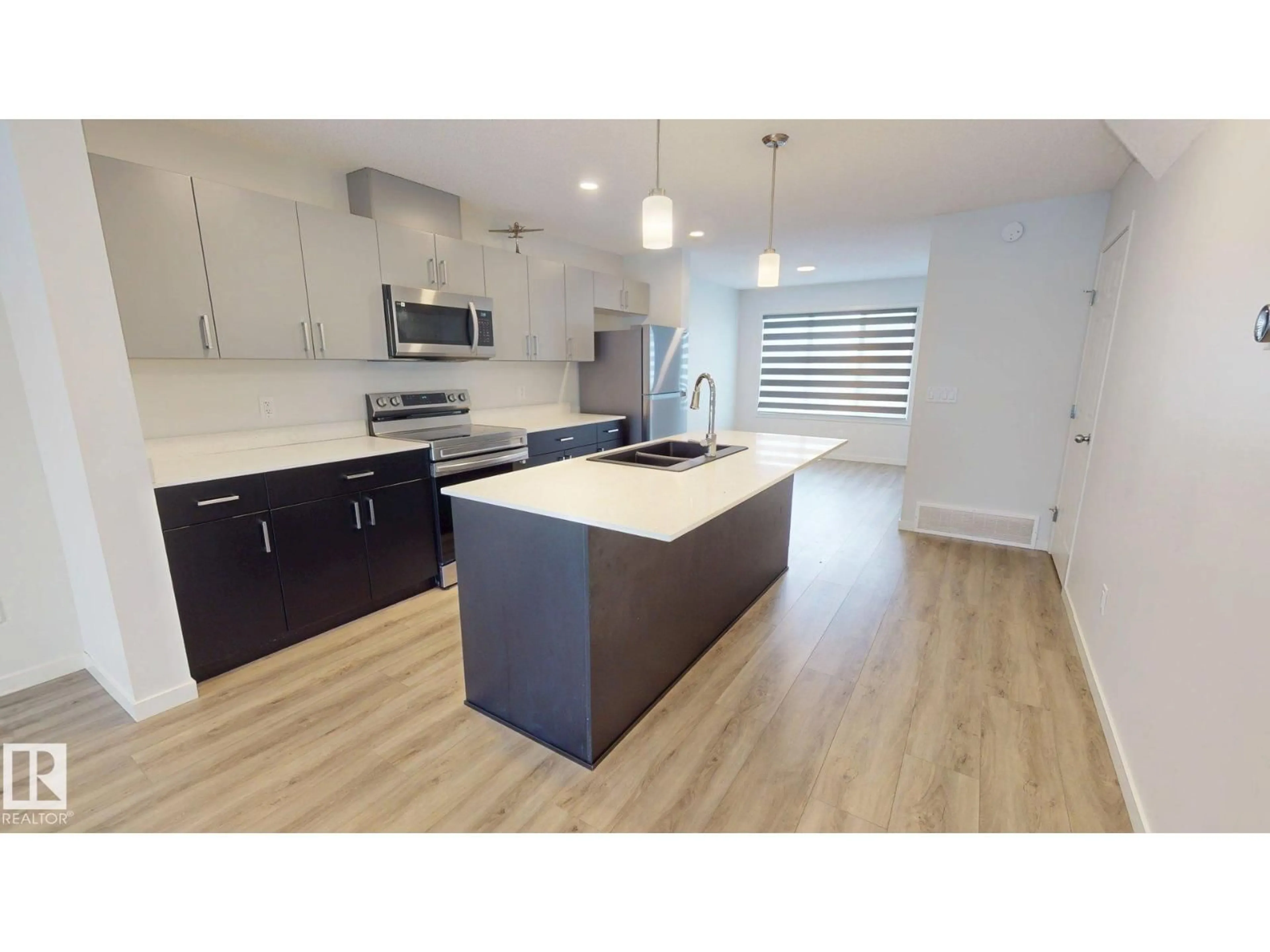 Open concept kitchen, wood/laminate floor for 7104 46A ST, Beaumont Alberta T4X3B8